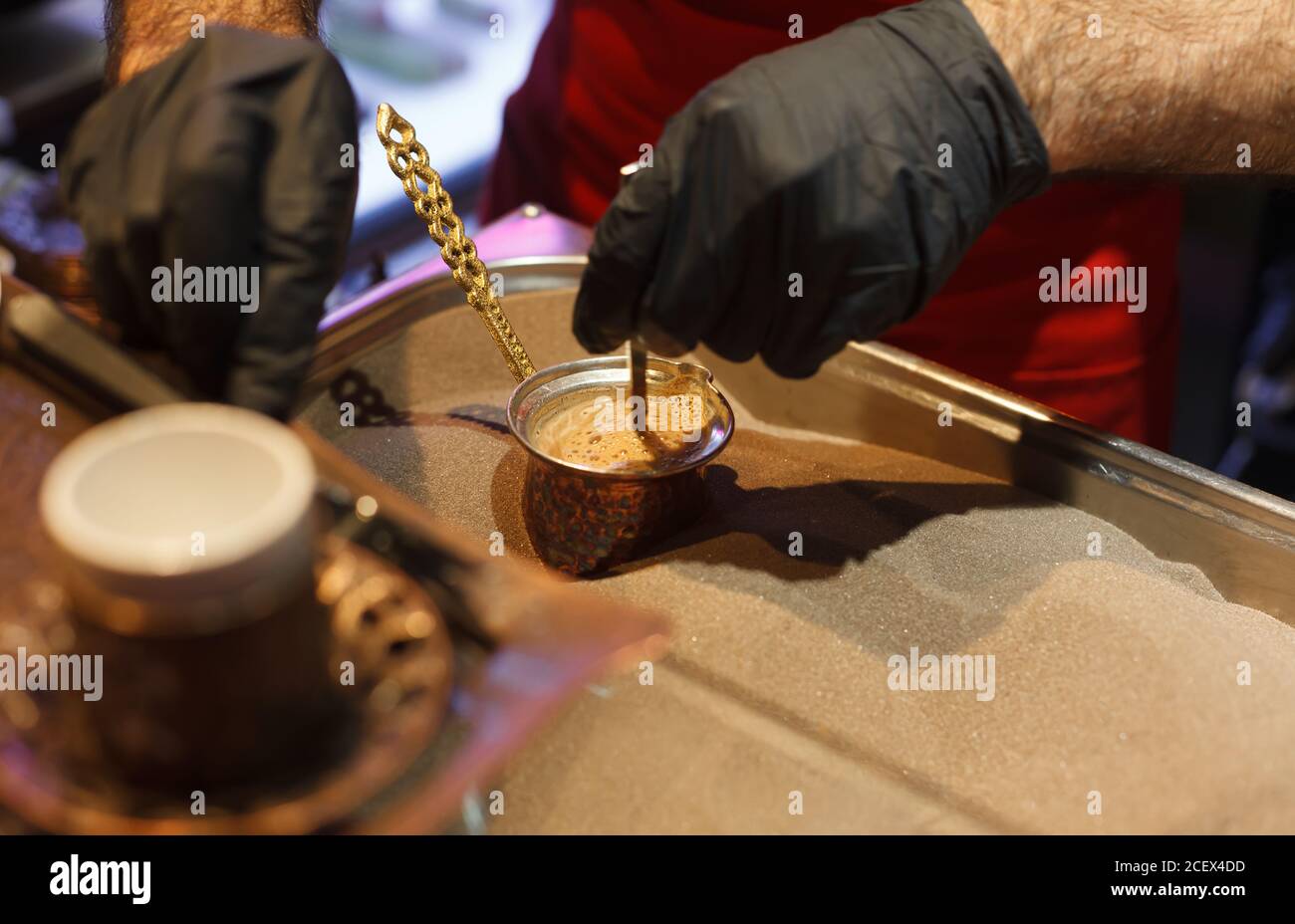 Making coffee on the sand close up, turkish coffee on a market, man in