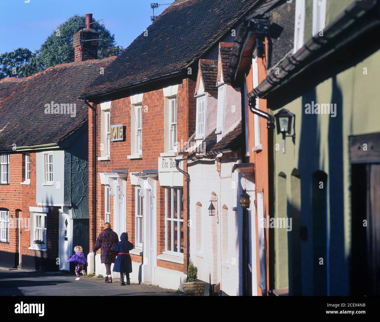 Mother and daughters walking past the old bakery in Castle Hedingham