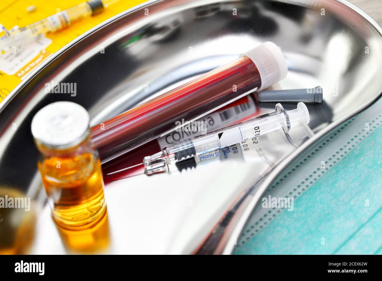 COVID-19 blood collection tube and syringe in a kidney dish, corona vaccination Stock Photo