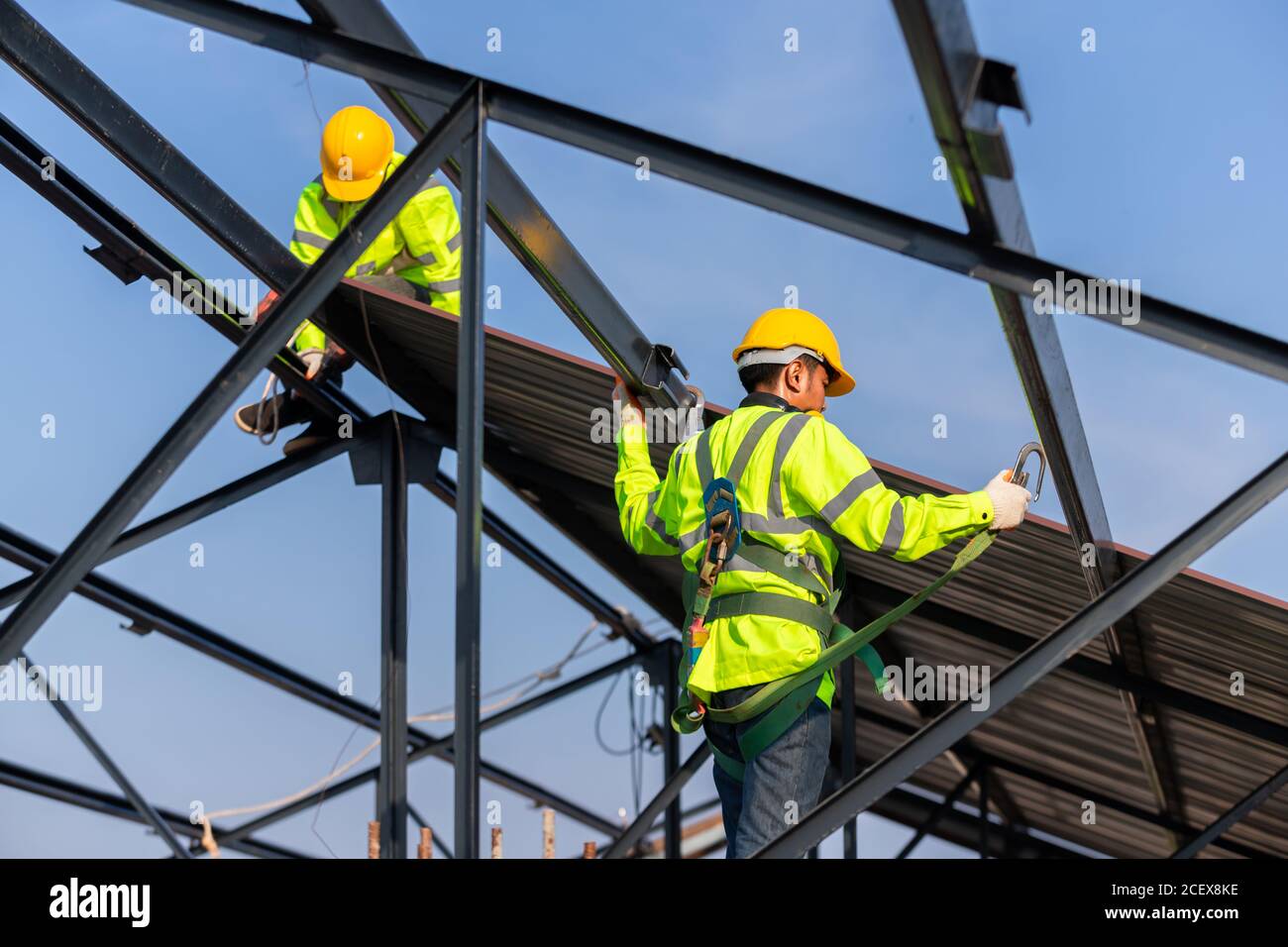 Asian roof construction worker wear safety height equipment to install