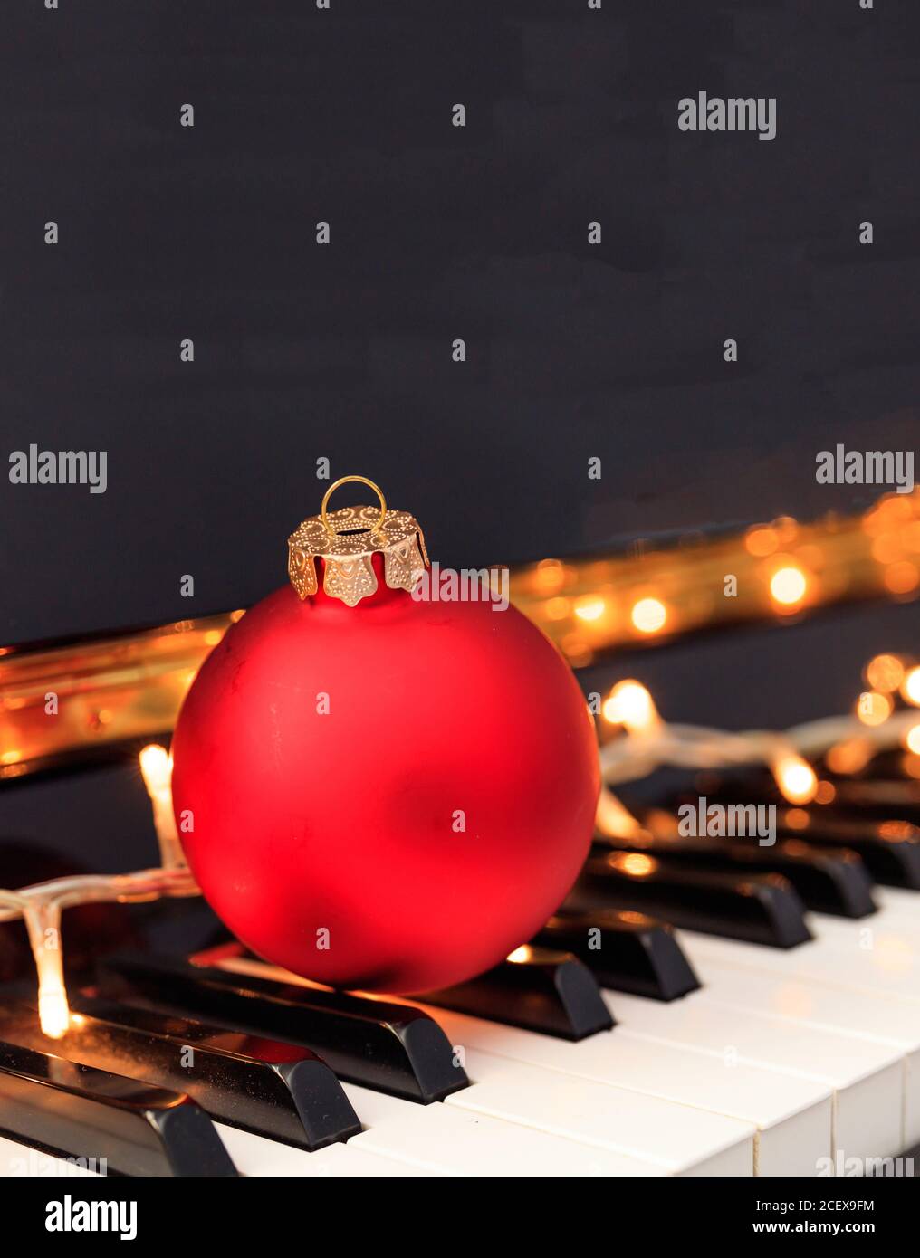 Chritmas ball red color on piano keyboard, closeup view. Xmas music