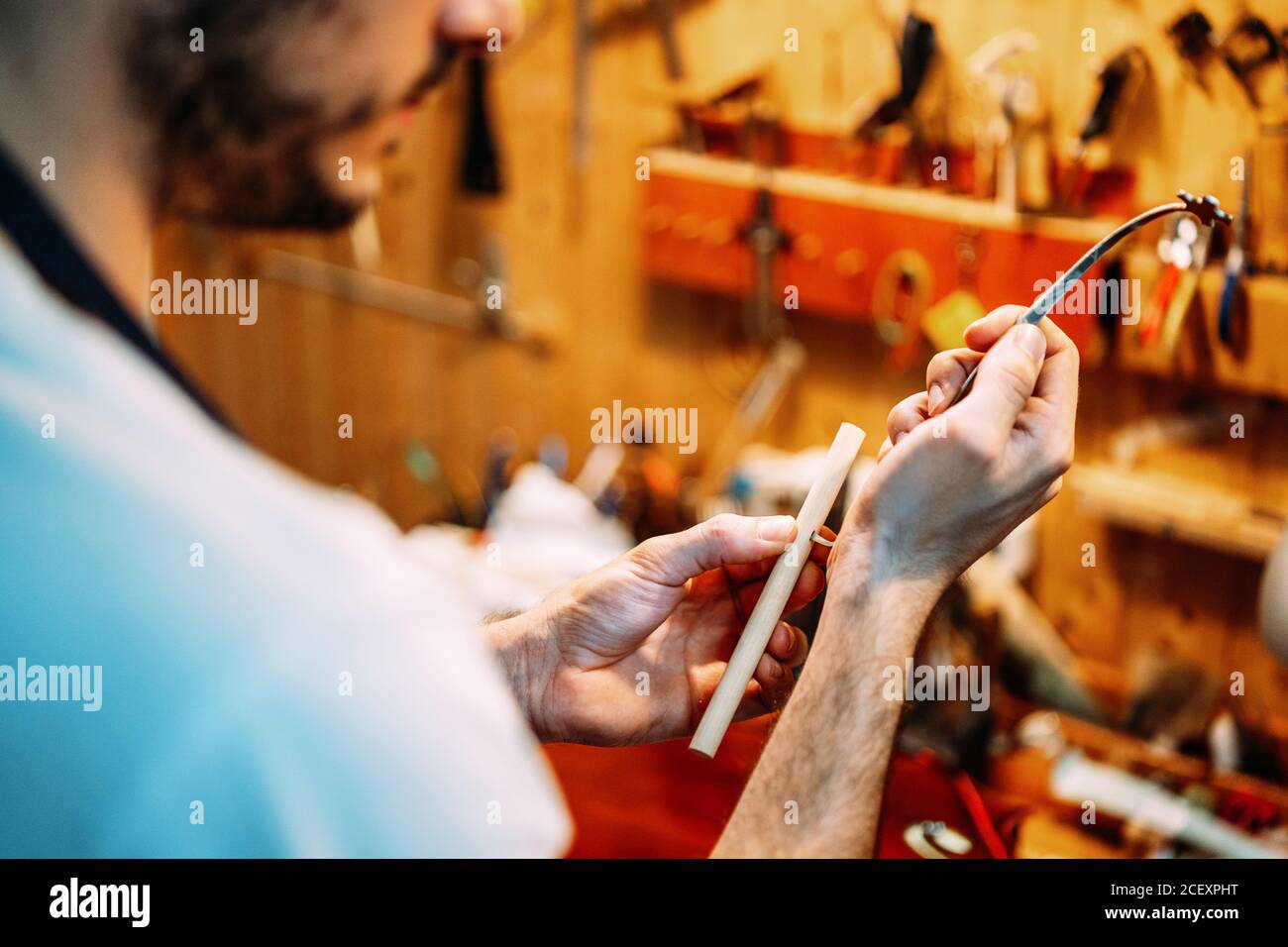 Side view of crop male artisan luthier fixing sound post on setter ...