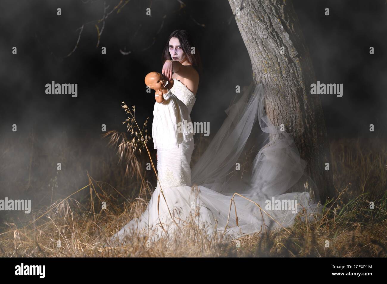 Horror Scene of a Woman Possessed holding a doll. High quality photo Stock Photo