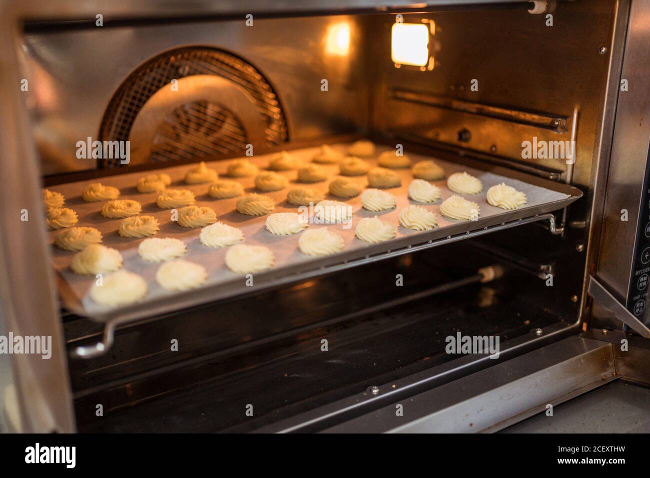 Heated oven with pastries inside at home bakery Stock Photo