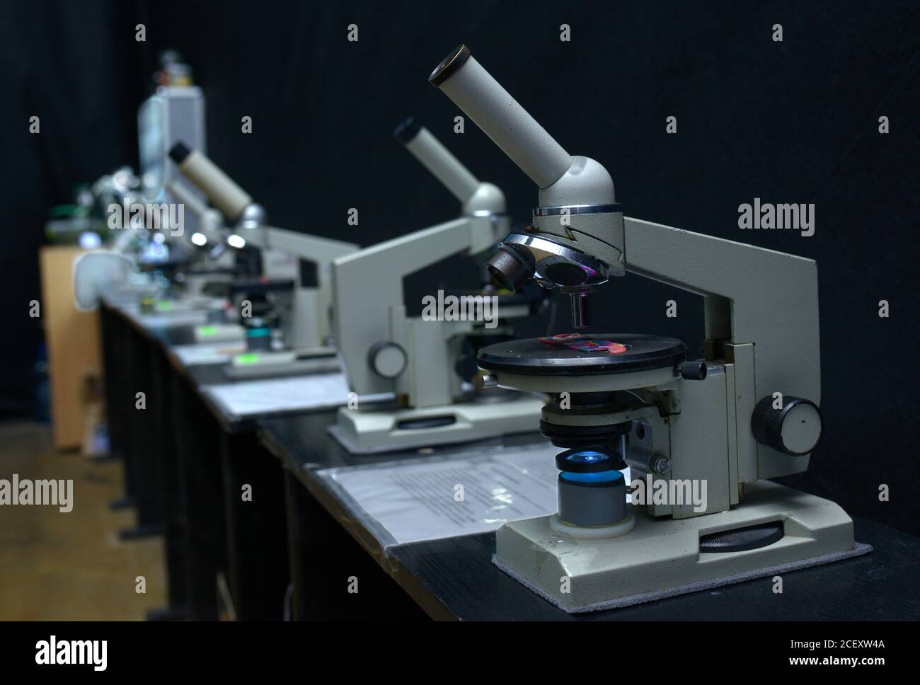 Microscopes set on the worktable of the school lab, black background Stock Photo