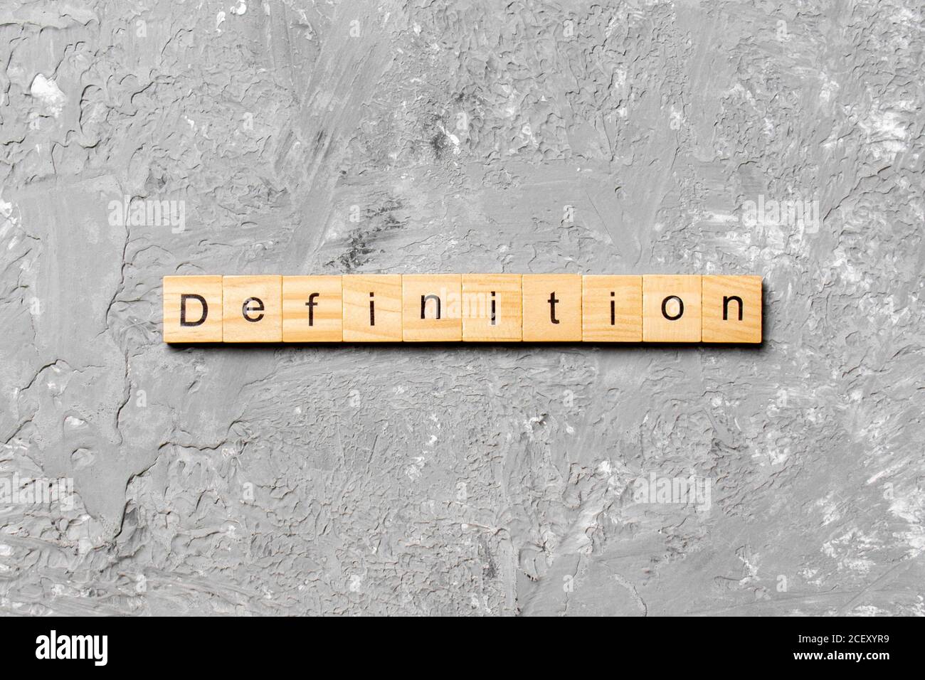 Definition word written on wood block. Definition text on cement table