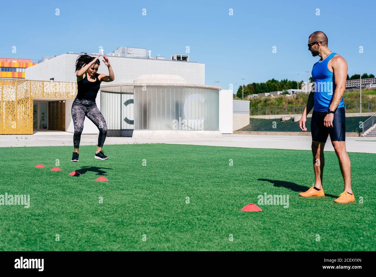 Full body young female athlete jumping on agility ladder during fitness