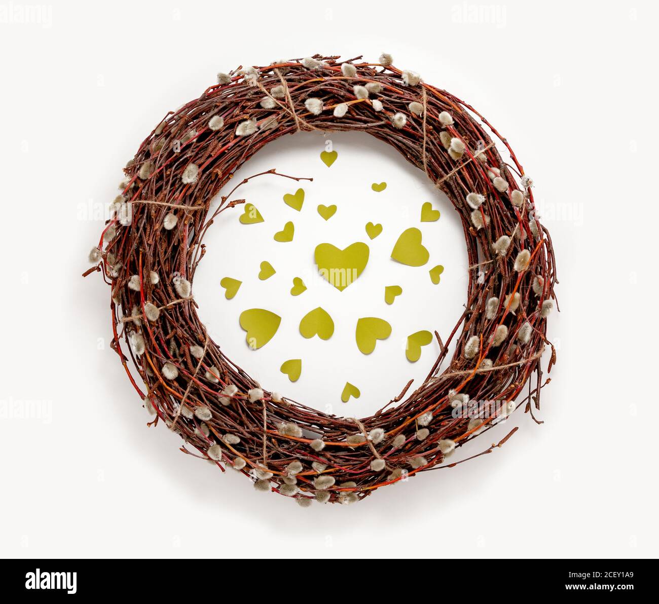 Spring Easter wreath, willow tree branches, green hearts, white background. Top view decorations flat lay spring banner Stock Photo