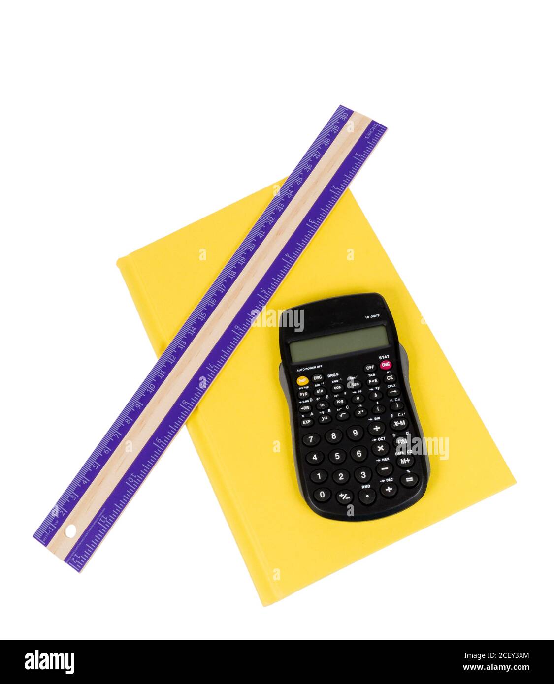 Nice shot of a purple ruler and calculator resting on a bright yellow colored book isolated on white background. Stock Photo