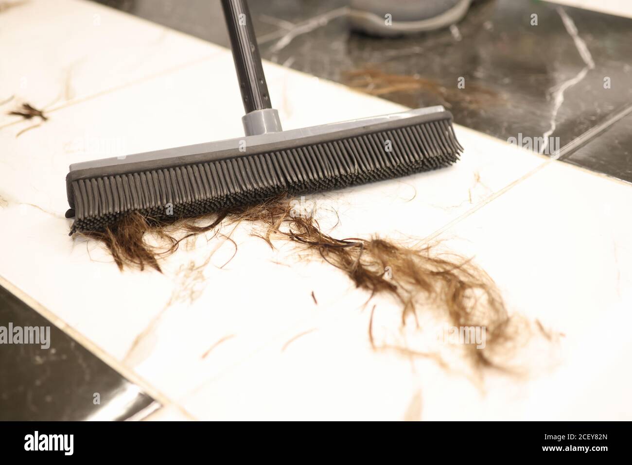 Floor brush is used to sweep cut hair in salon closeup Stock Photo Alamy