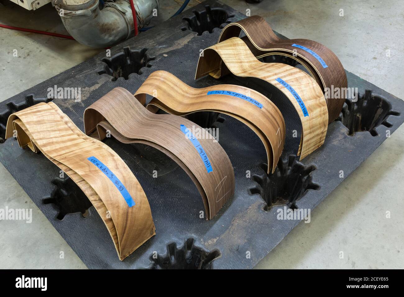 Curved exotic wood guitar sides are paired prior to gluing them together in the Taylor Guitar factory in Tecate, Mexico. Stock Photo