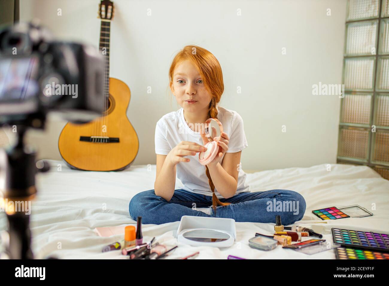 little caucasian girl want to be beauty blogger, she records video on professional camera. girl enjoy being interesting for subscribers. indoors Stock Photo