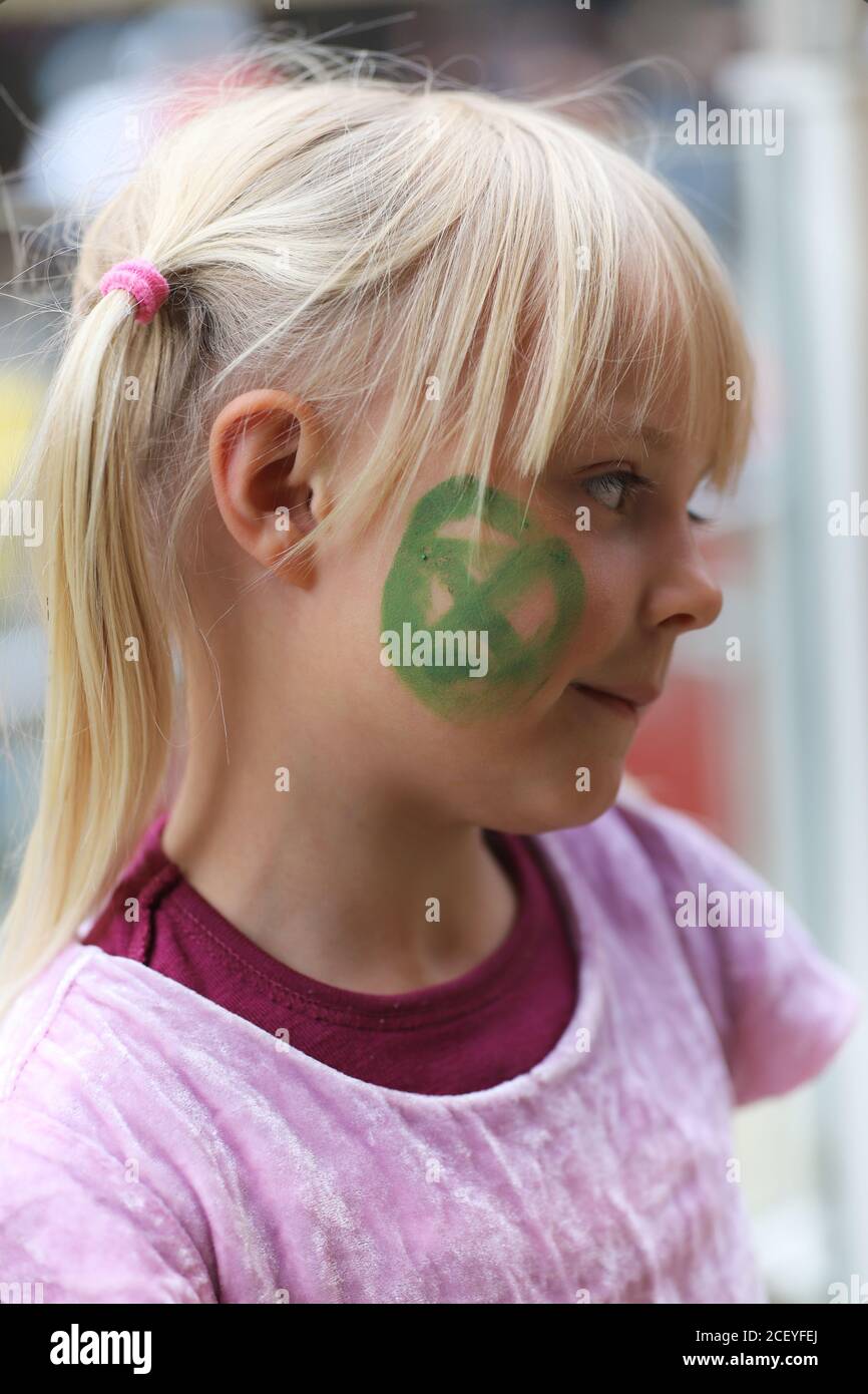 Cardiff, Wales, UK. 2nd Sep 2020. Extinction Rebellion Protestors gather at the Senedd in Cardiff highlighting the danger of rising tides and the risk of flooding in Cardiff due to climate change, 2nd September 2020. A child joins the protest with an Extinction Rebellion symbol painted on her face Credit: Denise Laura Baker/Alamy Live News Stock Photo