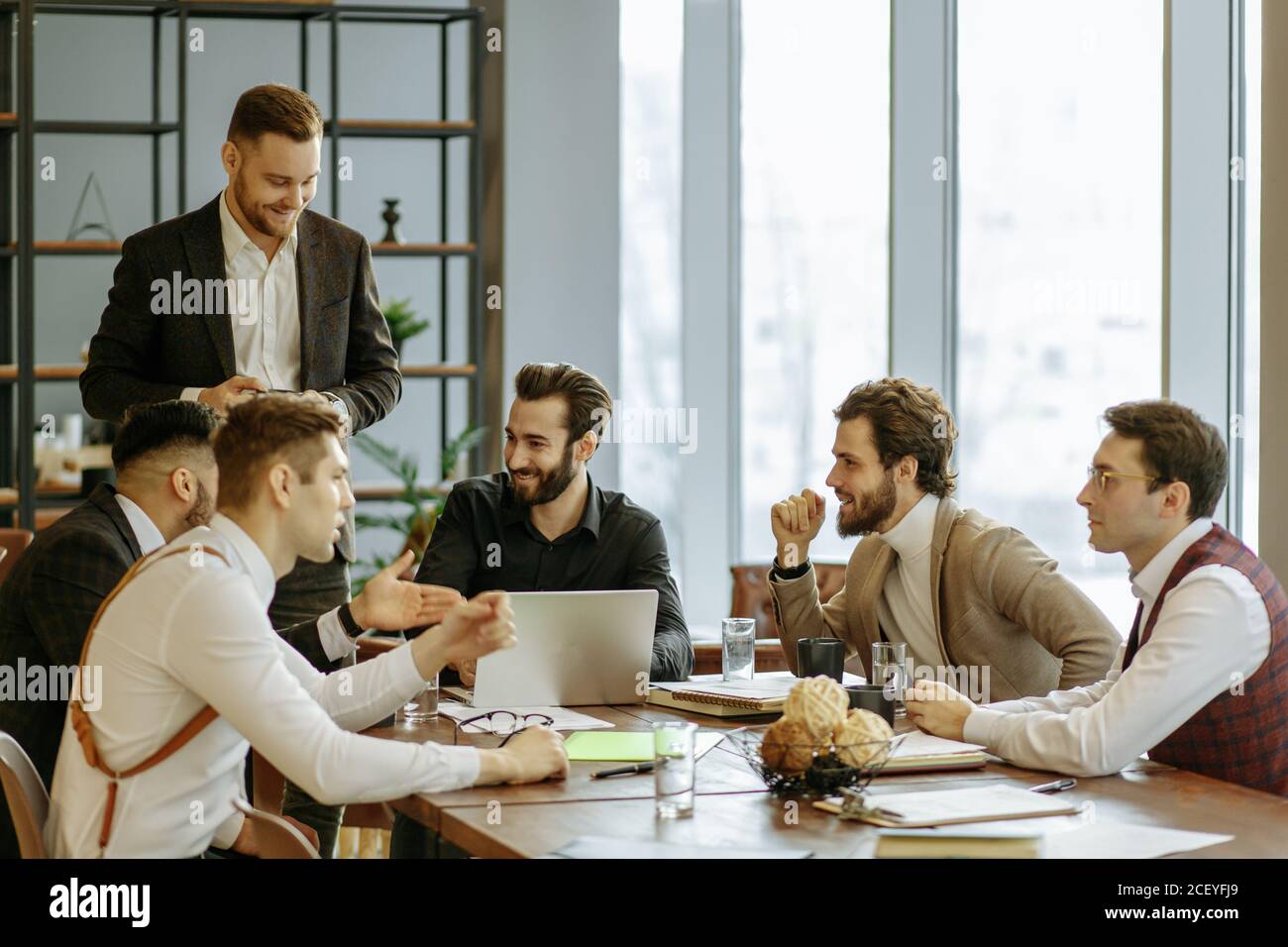 leisure time at work of business crew consisted of young men leaders in elegant suits, happy business partners or colleagues after successful conferen Stock Photo