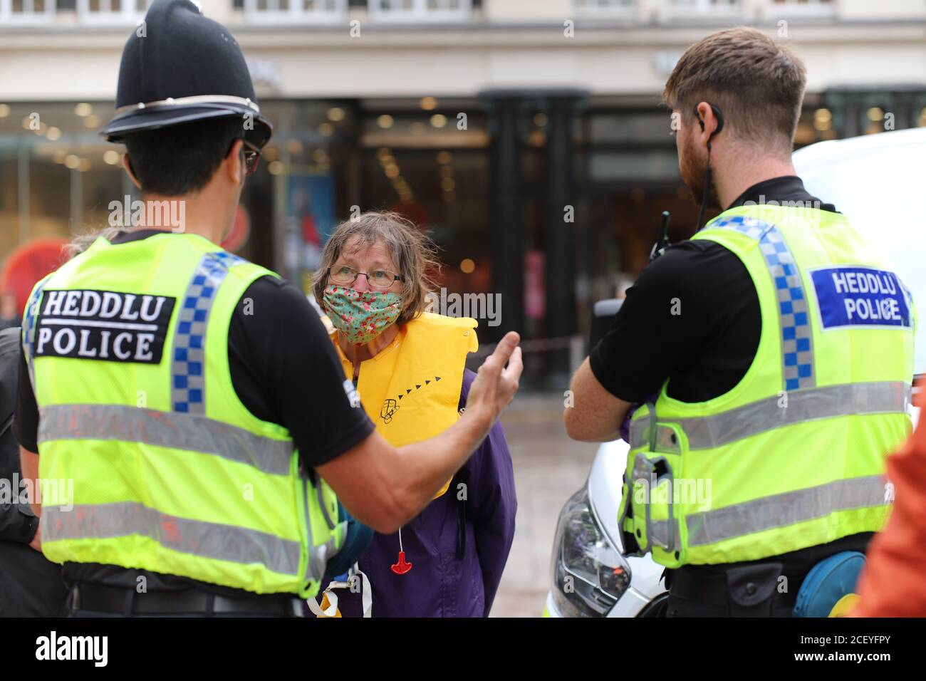 Cardiff, Wales, UK. 2nd Sep 2020. Extinction Rebellion Protestors gather at the Senedd in Cardiff highlighting the danger of rising tides and the risk of flooding in Cardiff due to climate change, 2nd September 2020. An older woman is confronted by two police men prior to being arrested Credit: Denise Laura Baker/Alamy Live News Stock Photo