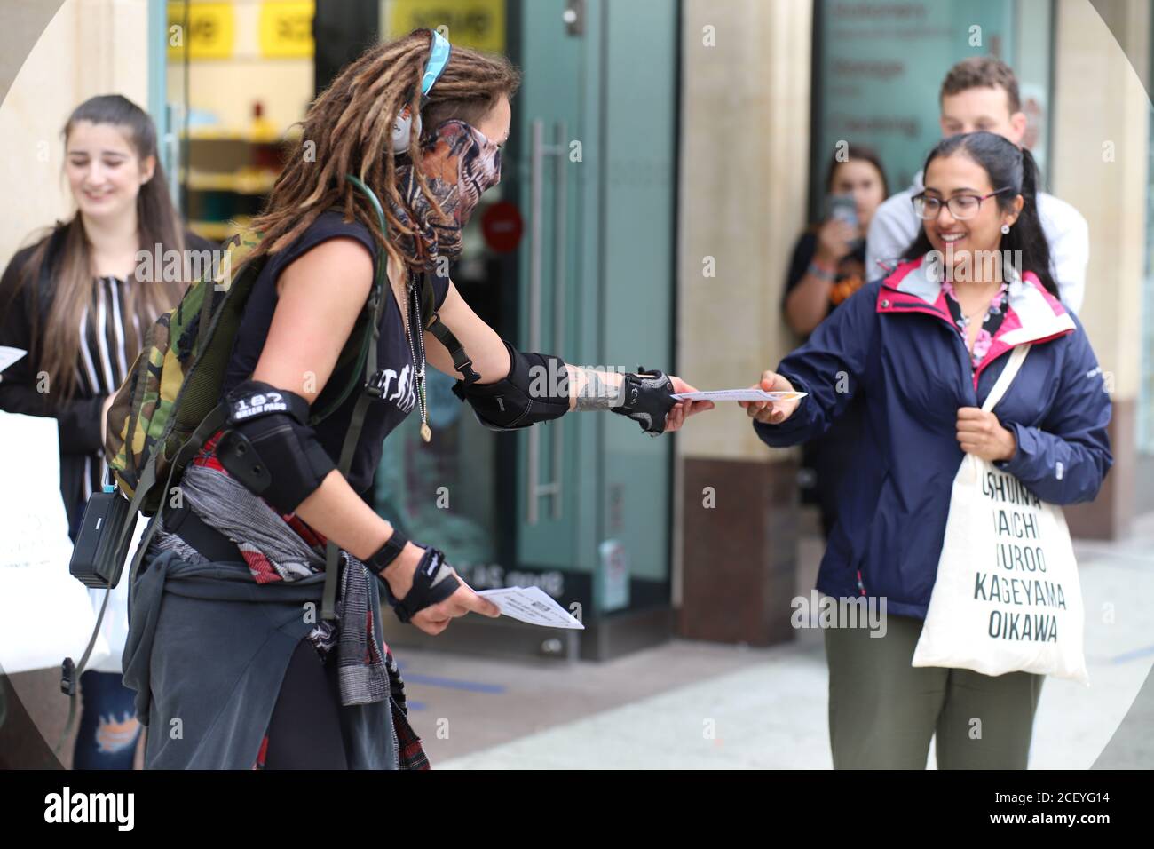 Cardiff, Wales, UK. 2nd Sep 2020. Extinction Rebellion Protestors gather at the Senedd in Cardiff highlighting the danger of rising tides and the risk of flooding in Cardiff due to climate change, 2nd September 2020. A female protestor hands out leaflets to the public Credit: Denise Laura Baker/Alamy Live News Stock Photo