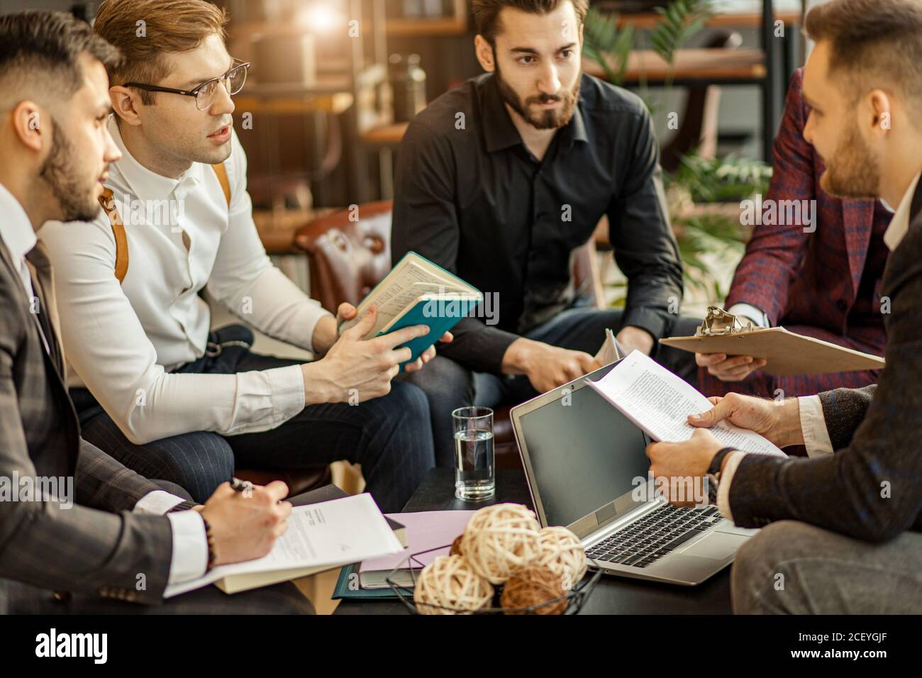 business coworking of young caucasian bearded men in office gathered to discuss business ideas, share experiences and opinions, successful cooperation Stock Photo