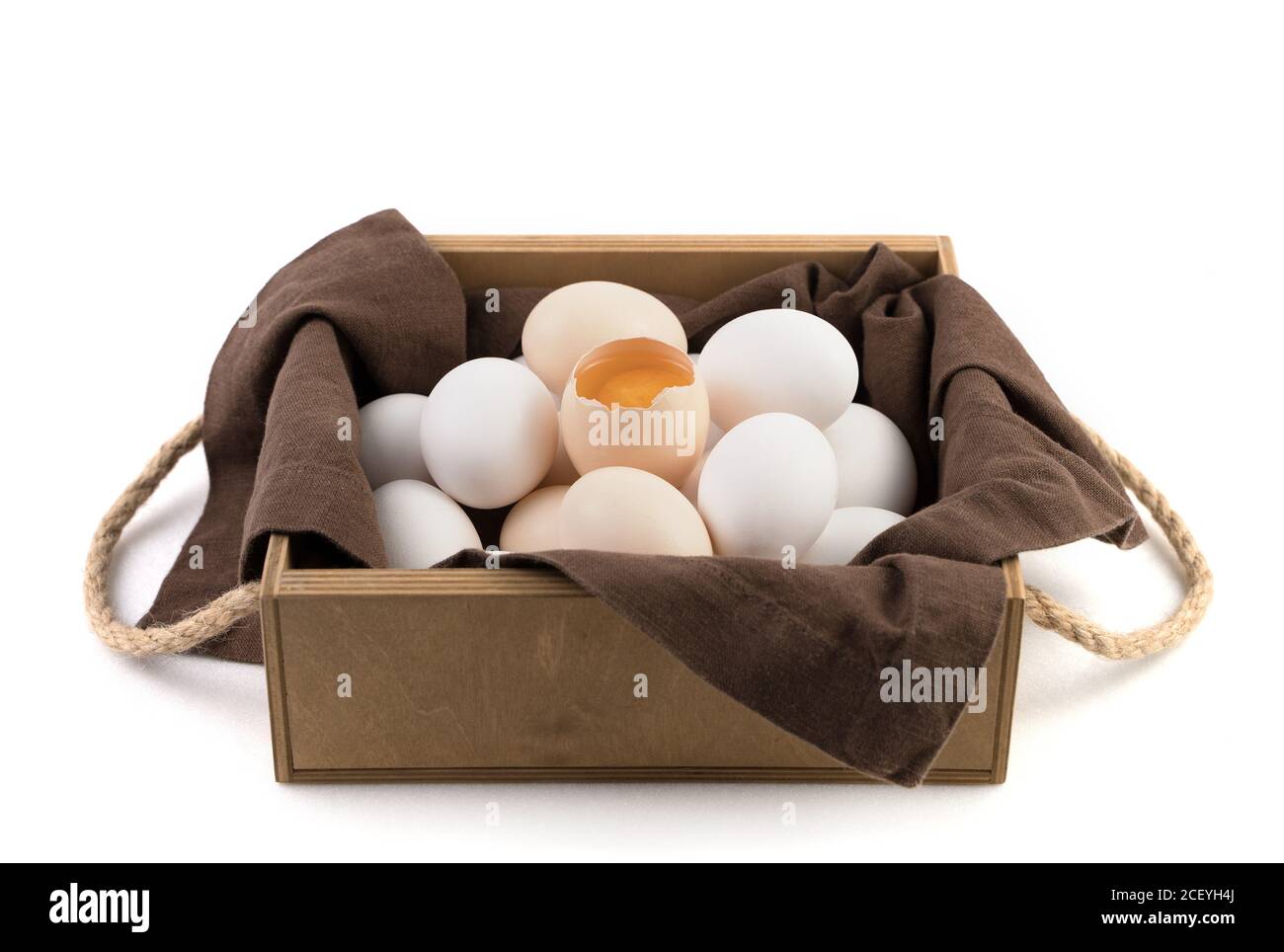 Fresh chicken eggs are white and brown with a broken egg in the center where the fresh yolk is visible. Stock Photo