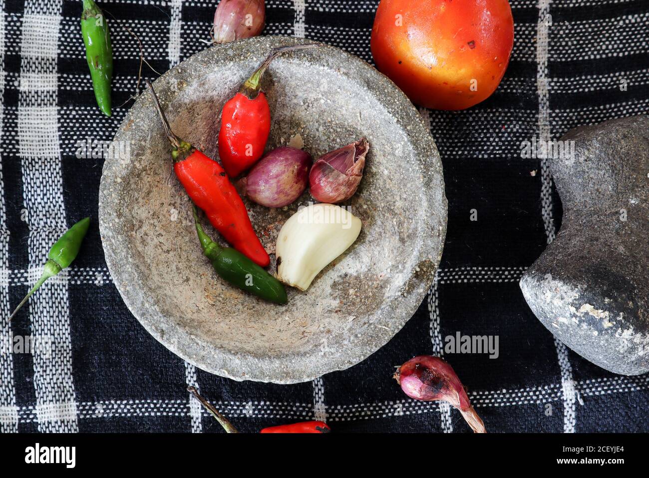 ingredients for making chili sauce with a stone mortar Stock Photo