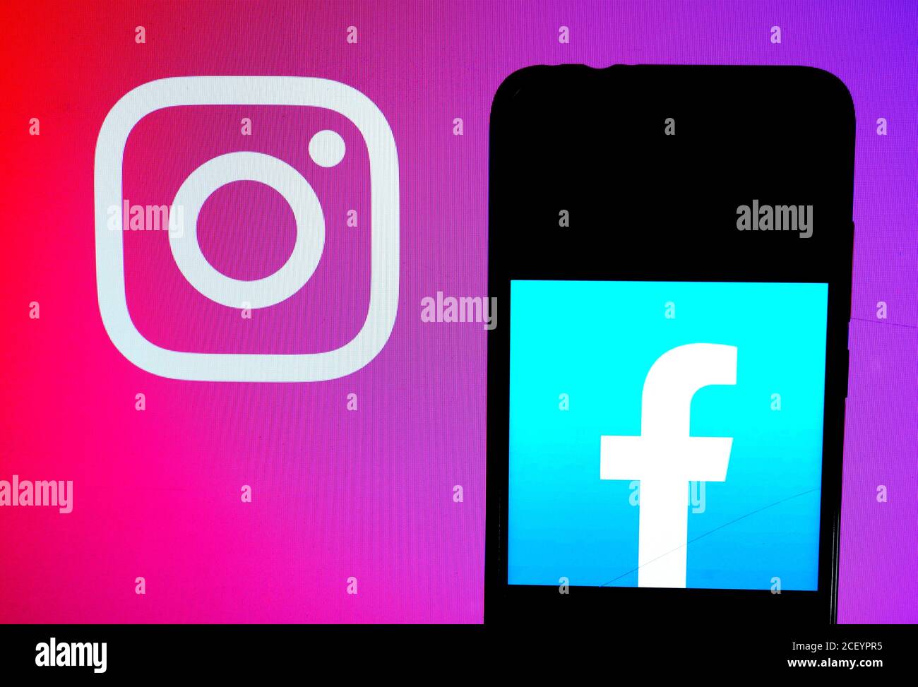 In this photo illustration a Facebook logo  seen displayed on a smartphone with an Instagram logo on the background. Stock Photo