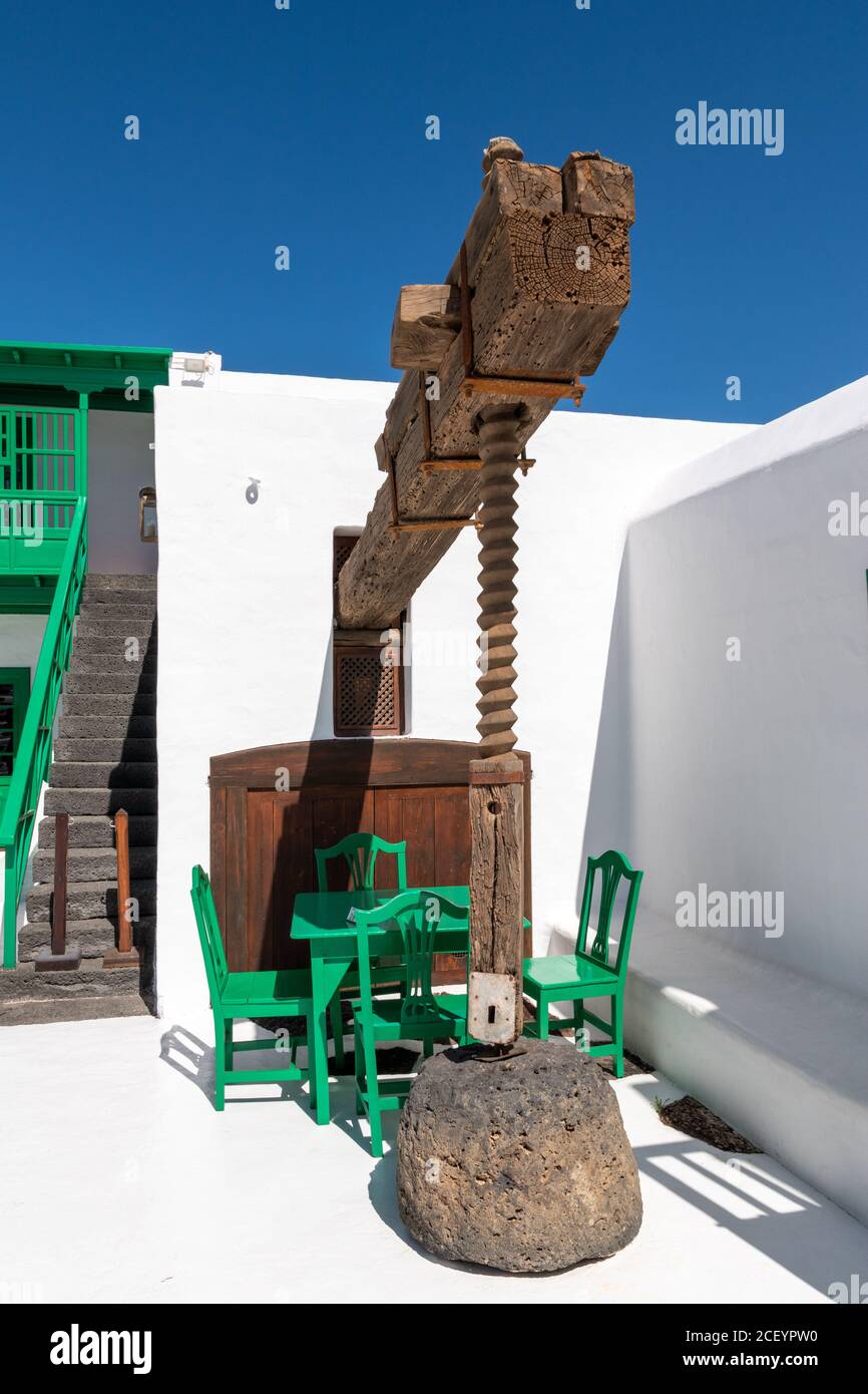 Grain mill and tables with green chairs in typical Canarian style