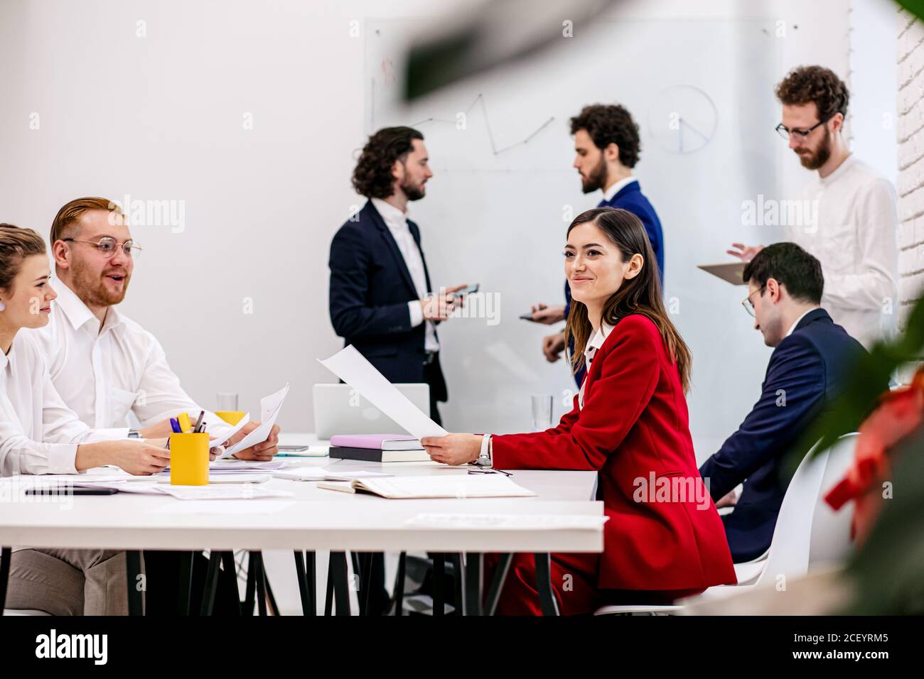young caucasian business team co-working in office, friendly crew consisted of young enthusiastic people gathered to discuss business ideas Stock Photo