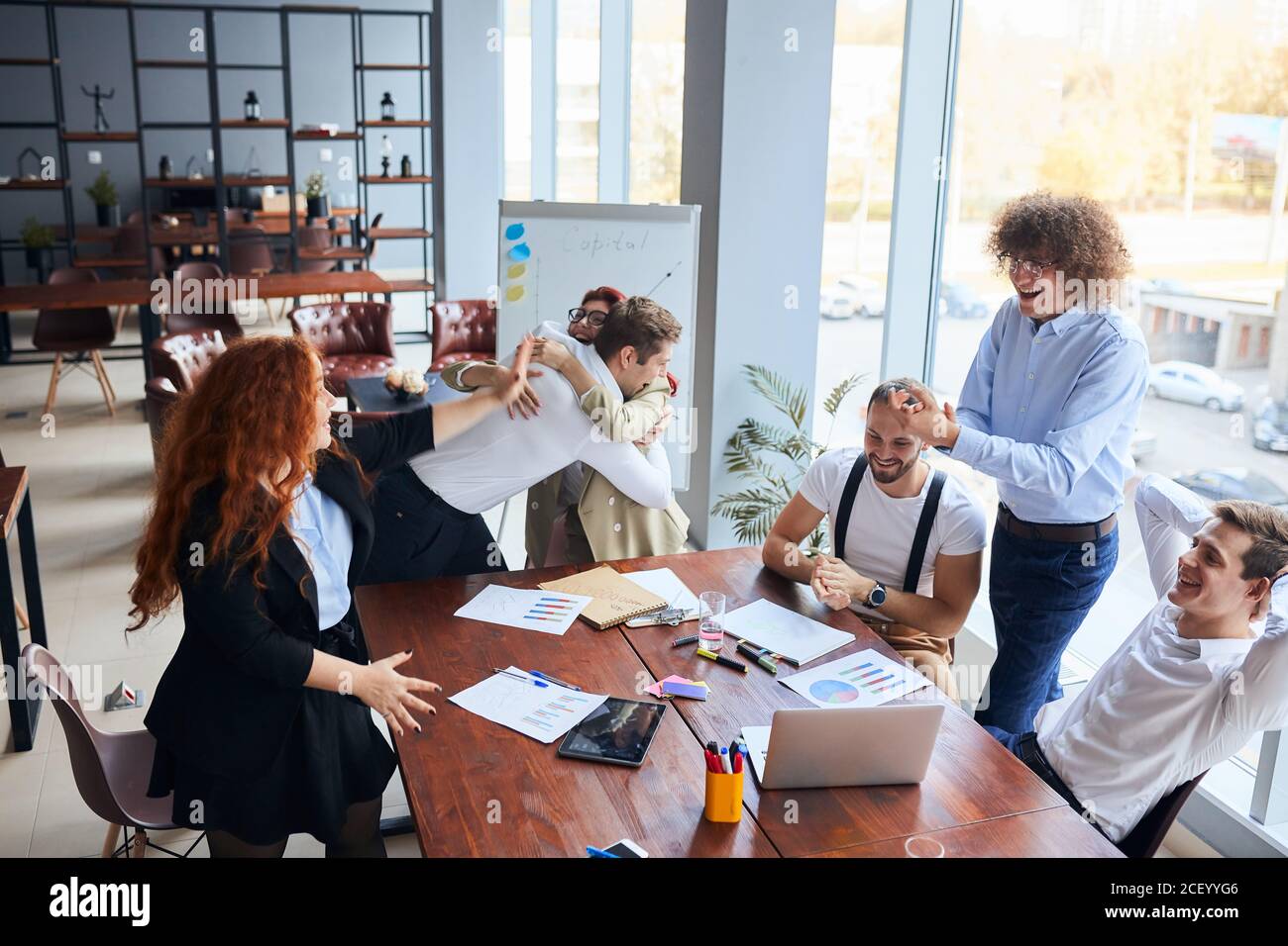 Everyday winners. Cheerful group of happy business people in formal wear looking at the laptop and gesturing, celebrate winning Stock Photo