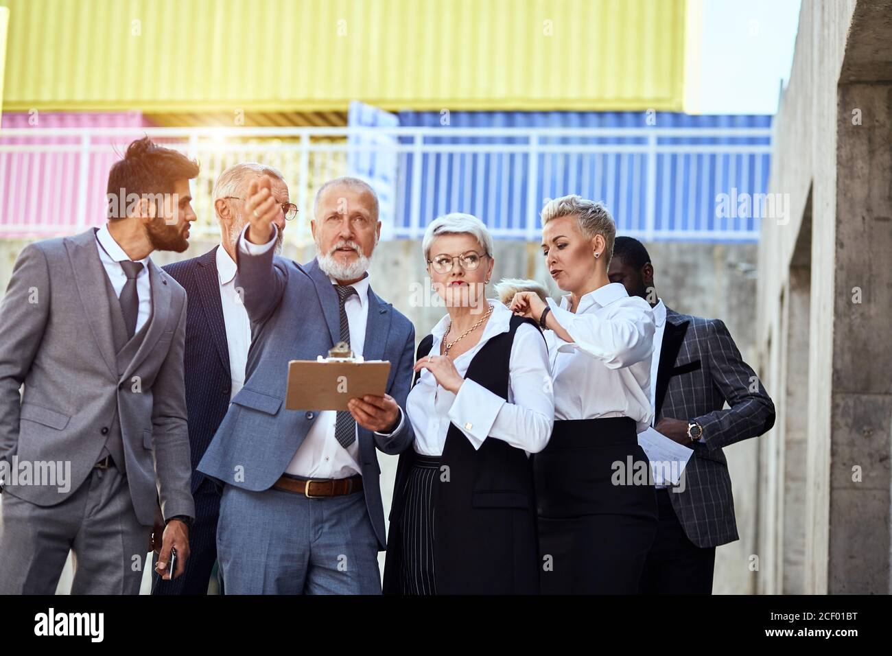 Group of businessmen wear stylish suits in the street move. Man point ...