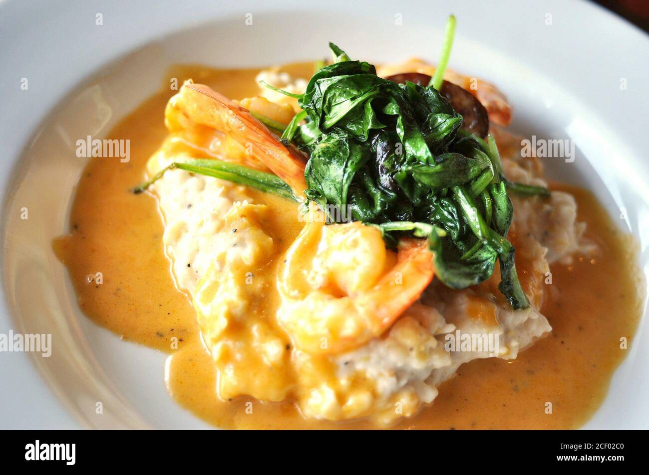 Shrimp and Grits with sauteed spinach Stock Photo