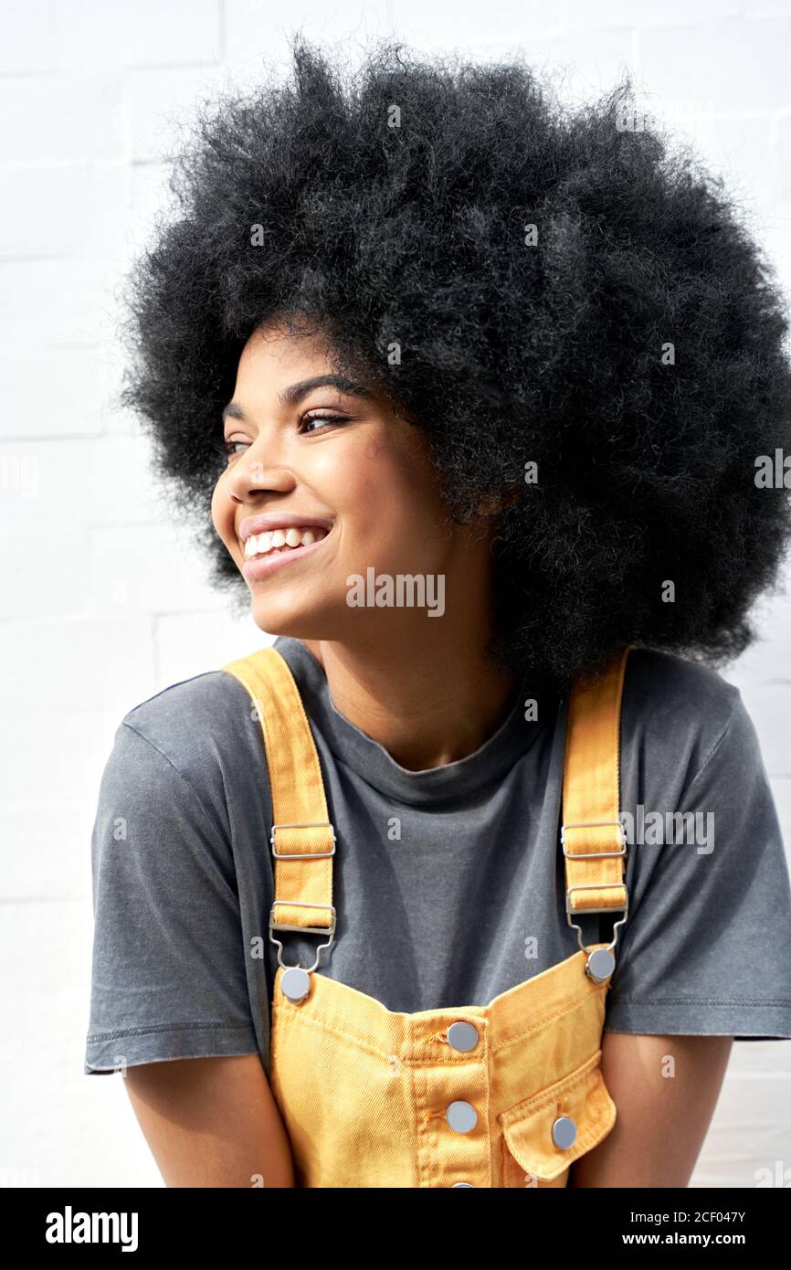 Smiling African lady with Afro hair laughing standing on white background. Stock Photo