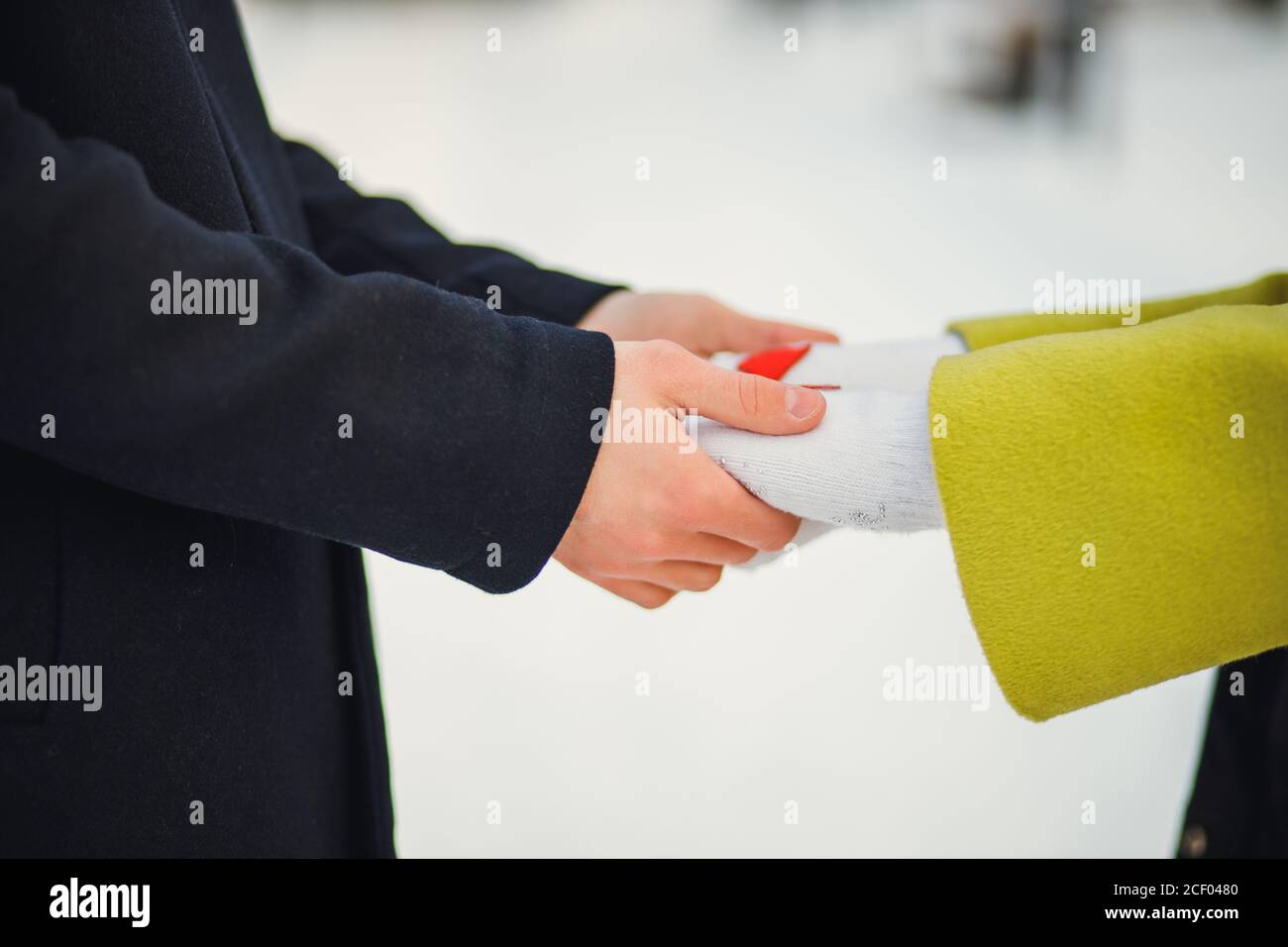 close-up hands of couple in love, man and woman have romantic date at winter street. caring man hold woman's hands. love concept. outdoors Stock Photo