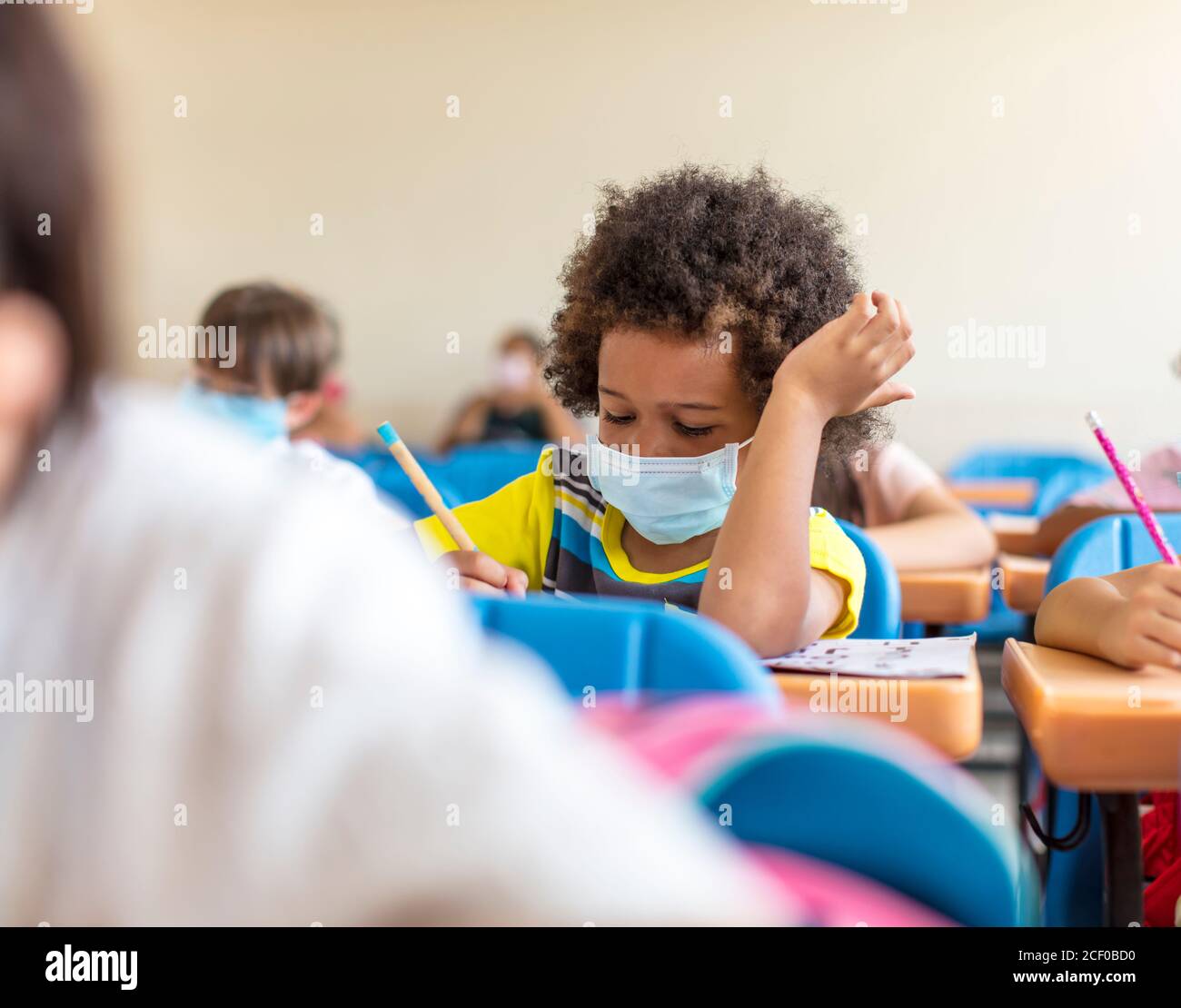 school boy wearing mask and study in classroom Stock Photo - Alamy