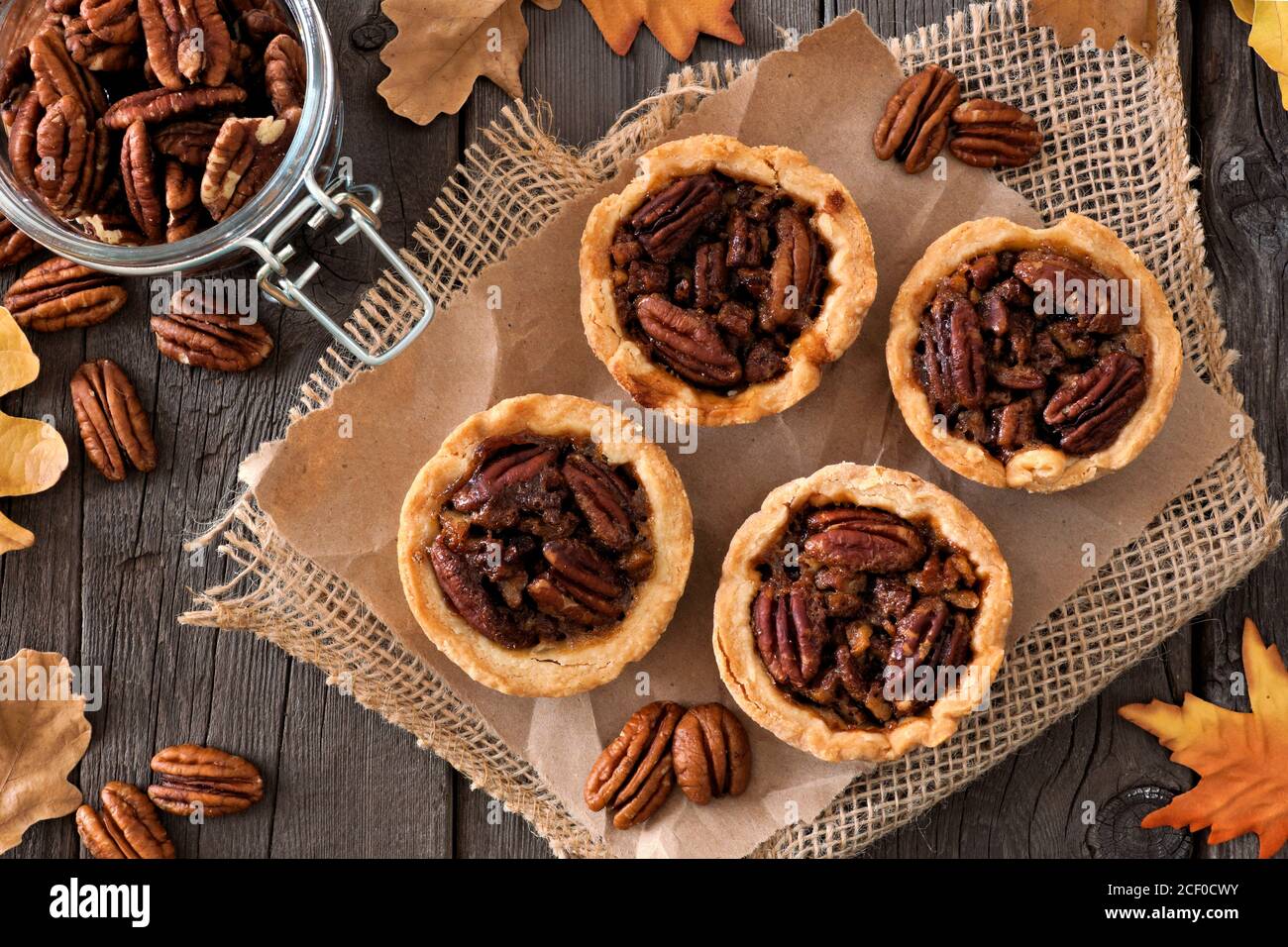 Mini pecan pie tarts, above view table scene on a rustic wood background Stock Photo