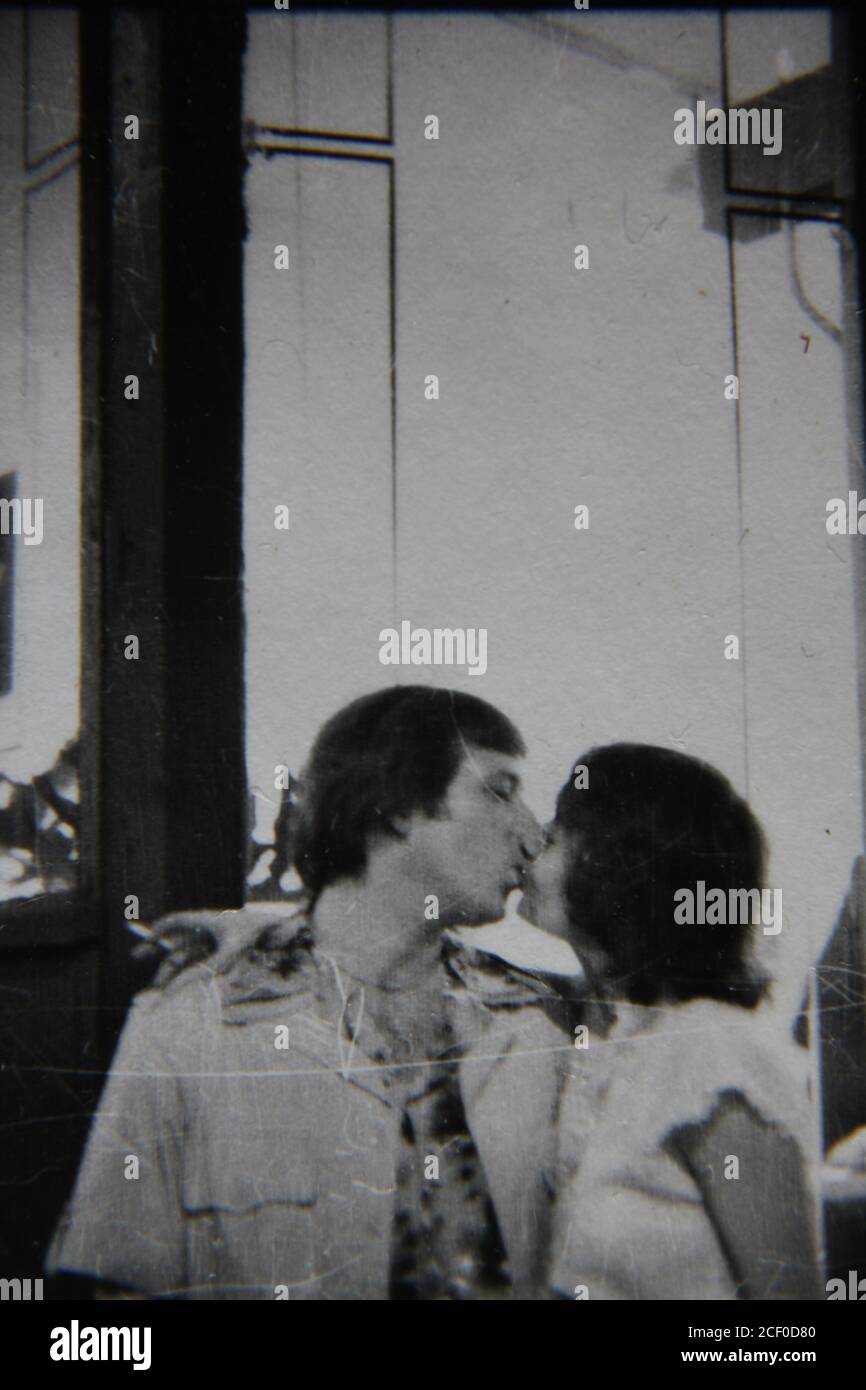 Fine 1970s vintage black and white photography of a couple kissing in public. Stock Photo