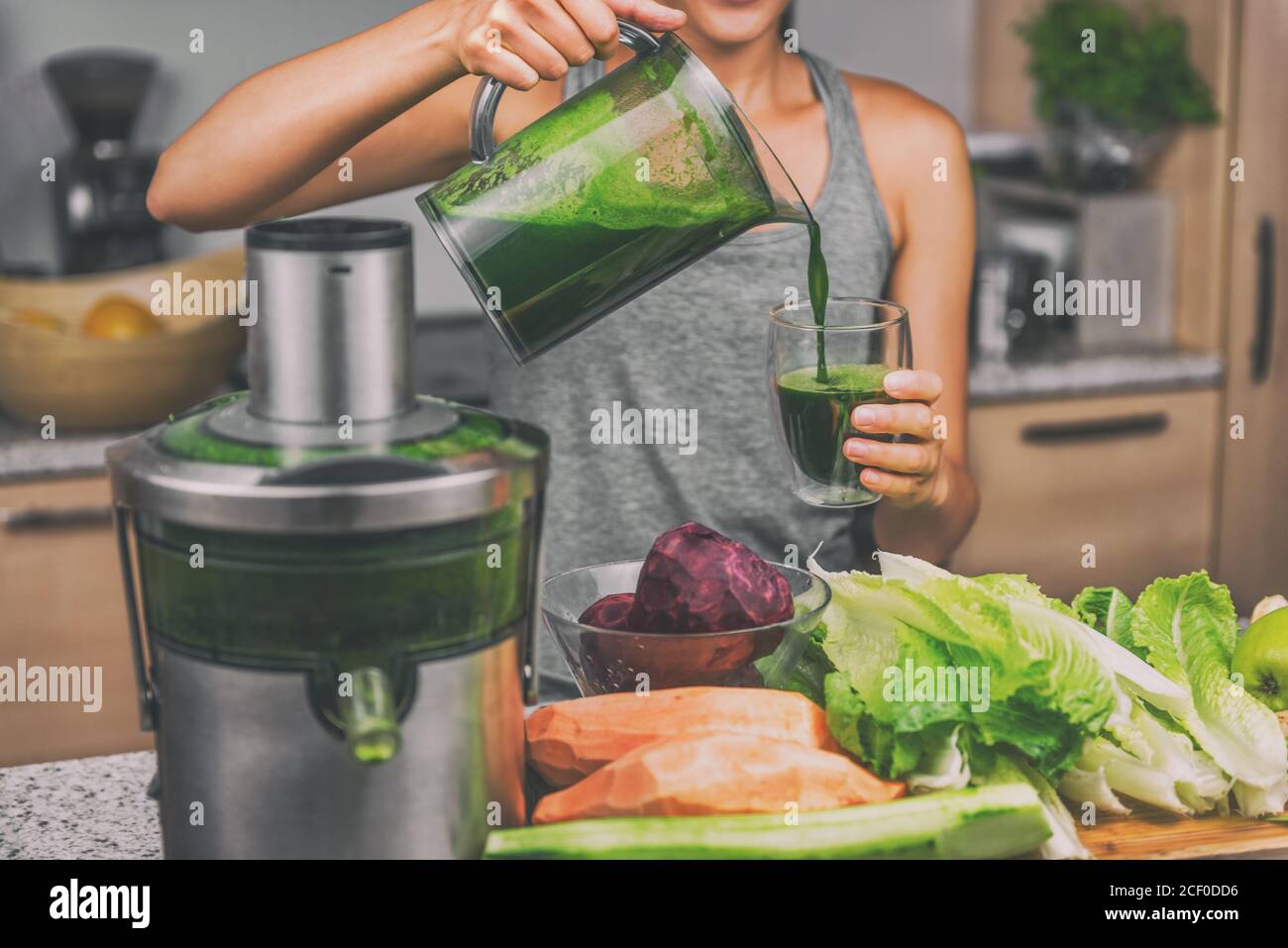 Woman juicing green juice with home juice machine Stock Photo