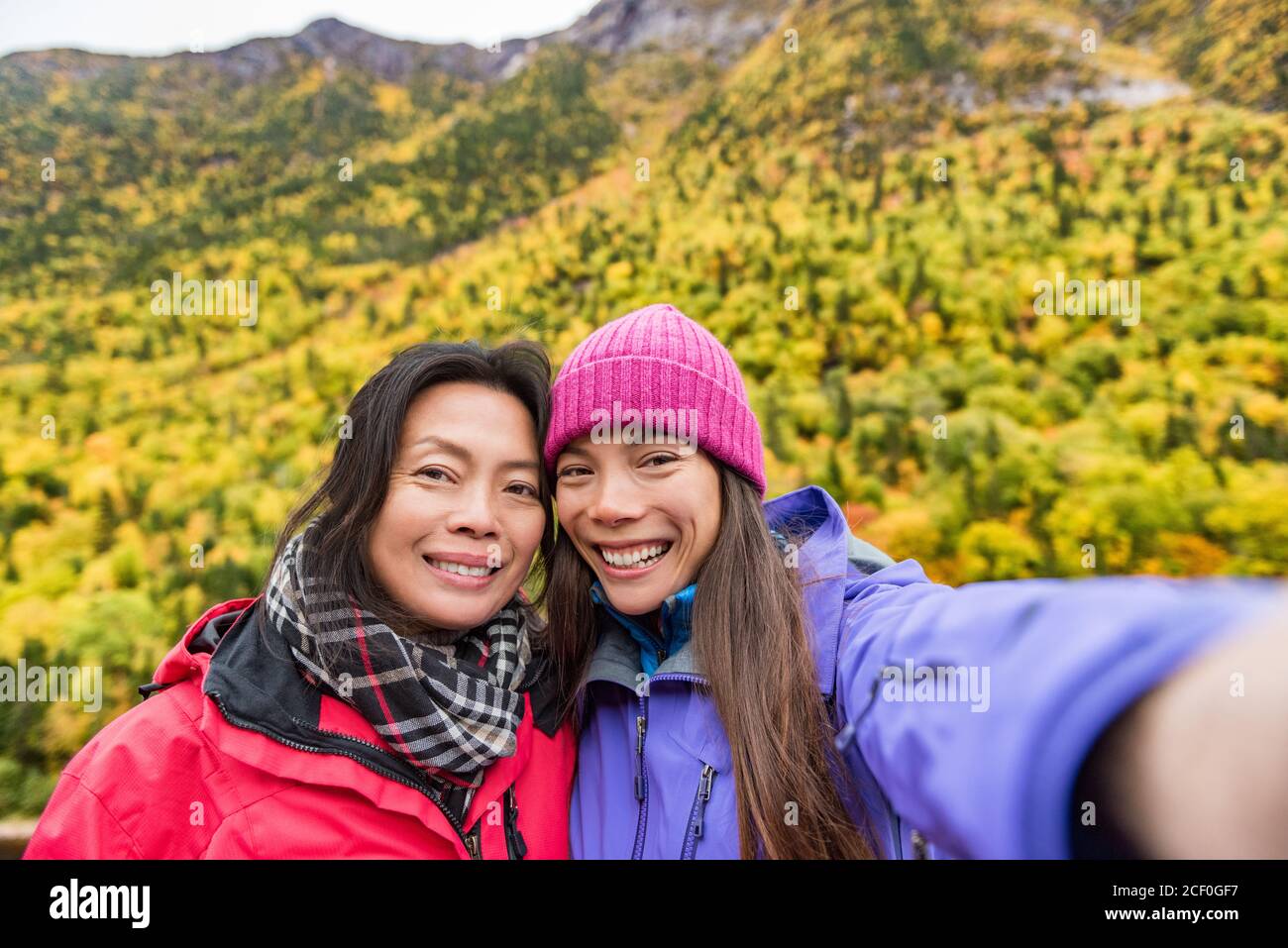 Mother daughter women taking selife on autumn hike Stock Photo