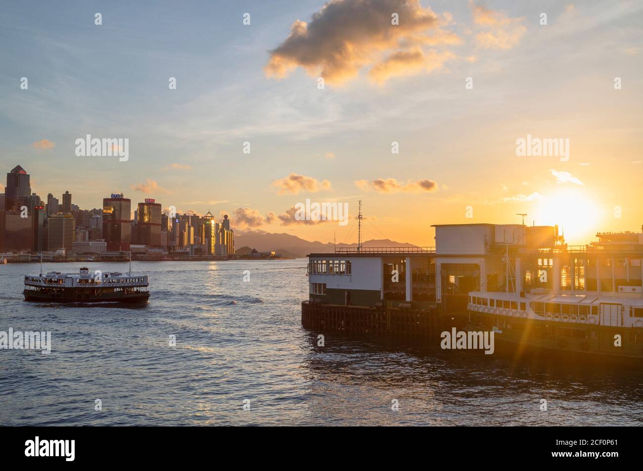 Star Ferry approaching Star Ferry Pier at sunset, Tsim Sha Tsui, Kowloon, Hong Kong Stock Photo