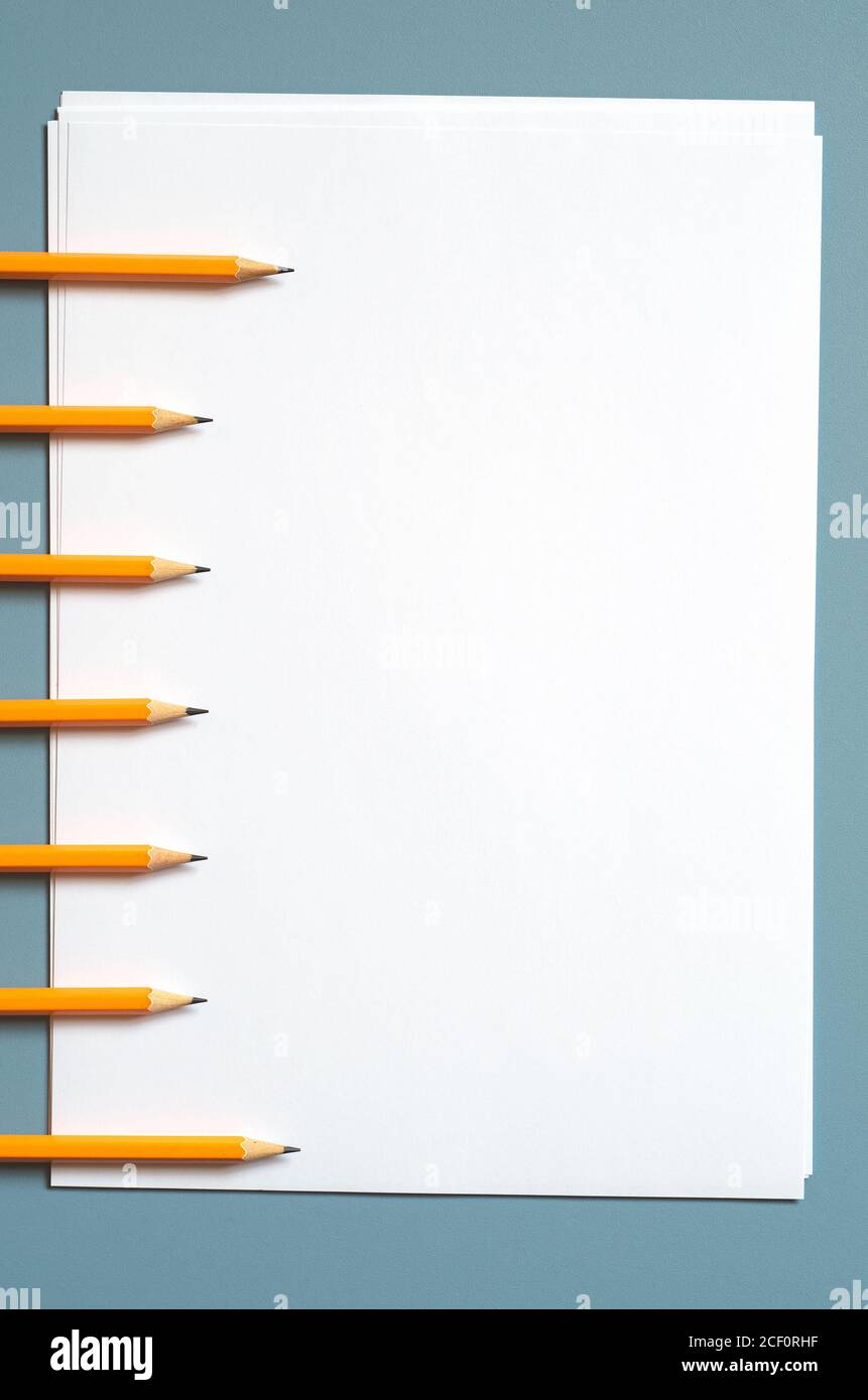 Seven pencils and a blank sheet of paper on desk, top view Stock Photo