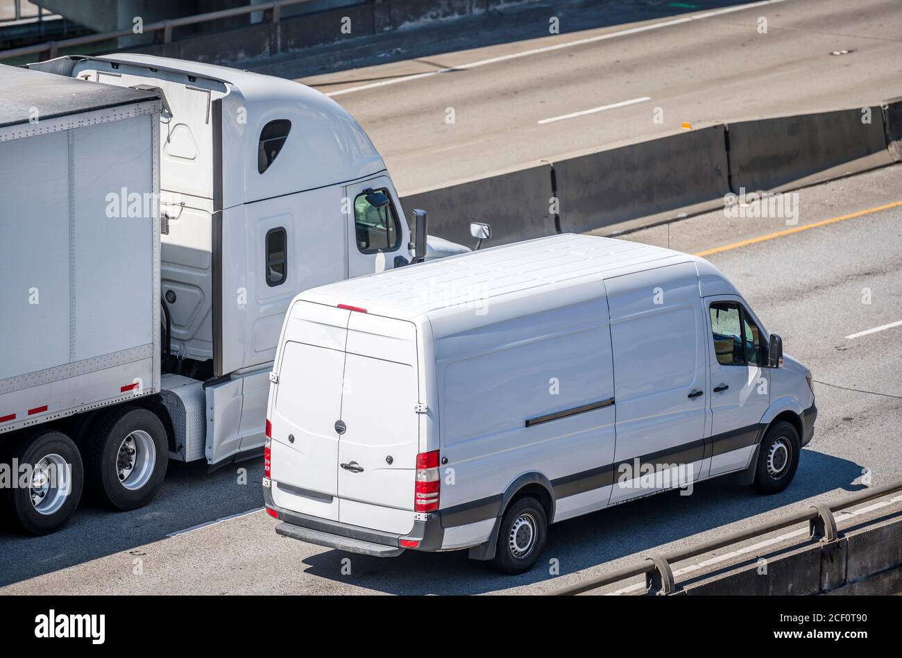 Team of Big rig semi truck with dry van semi trailer and compact cargo mini van  driving side by side on the multiline highway road working hard togeth  Stock Photo - Alamy