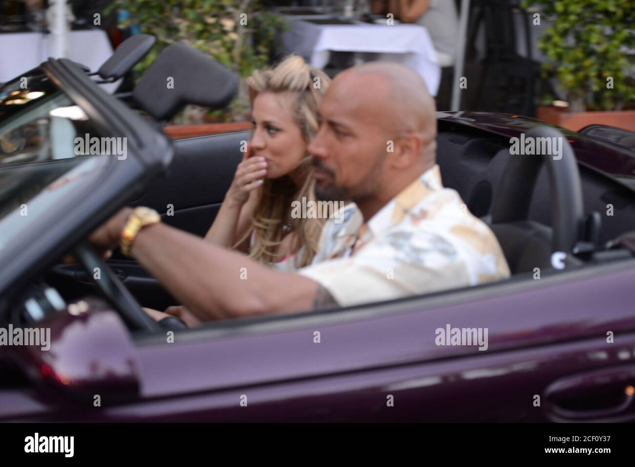MIAMI BEACH, FL - APRIL 25: (EXCLUSIVE COVERAGE) Israli super-model Bar Paly and Dwayne 'The Rock' Johnson film a scene together in a purple Chrysler Prowler, on the set of Pain and Gain which is directed by Michael Bay. Pain and Gain is about a pair of bodybuilders in Florida get caught up in an extortion ring and a kidnapping scheme that goes terribly wrong. on April 25, 2012 in Miami Beach, Florida. ( Credit: Storms Media Group/Alamy Live News Stock Photo