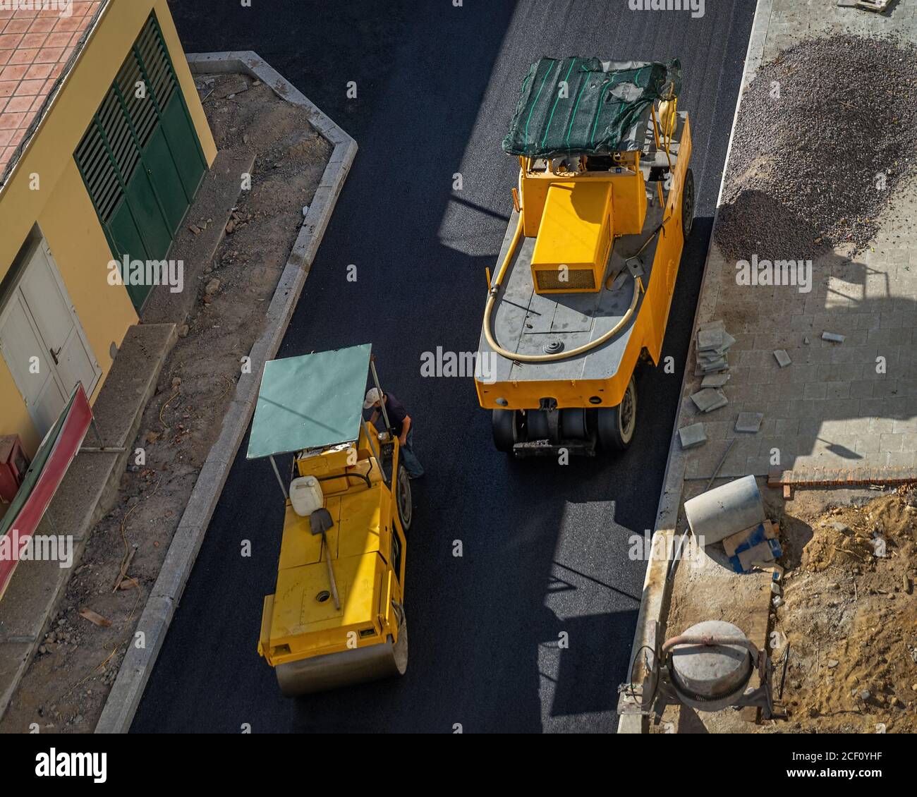 Asphalt road construction site with paving machine compacting asphalt ...