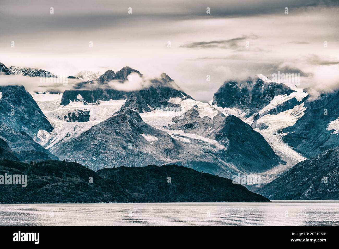 Glacier Bay National Park, Alaska, USA. Alaska scenic cruise travel view of snow capped mountains at sunset. Beautiful snowy mountain peaks landscape Stock Photo