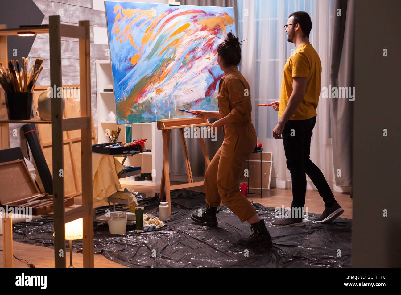 Man and woman painting on canvas in art studio. Modern artwork paint on ...