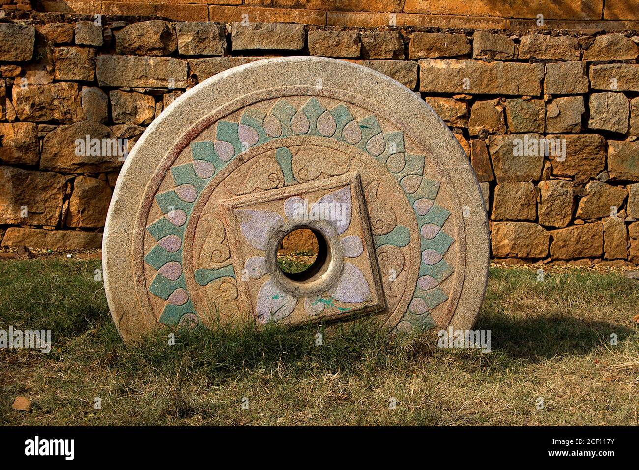 Carved, painted stone wheel embedded in ground at Nandish Temple near Nandi Hills, Bengaluru, Karnataka, India, Asia Stock Photo