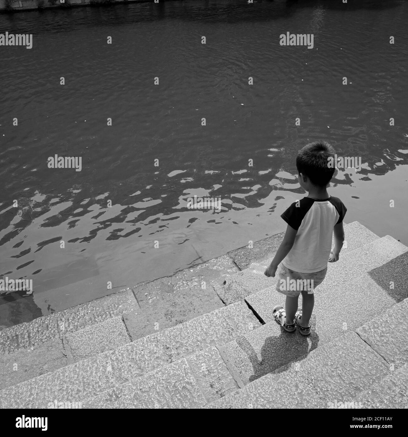 A Child stand in front of a river at Wuzhen China Stock Photo