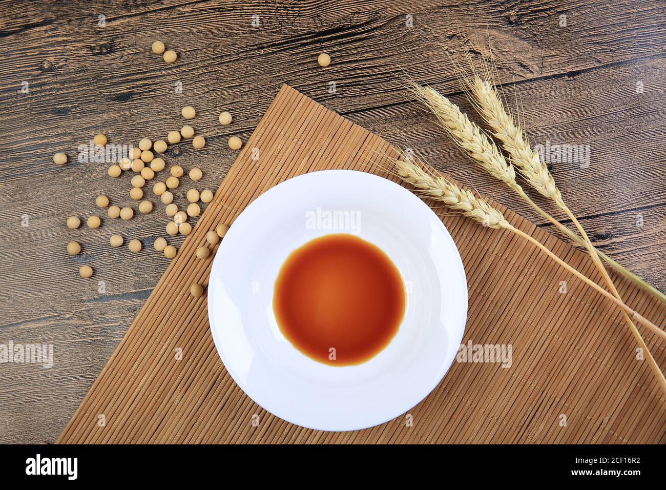 Wood grain, soy sauce, plate, wheat ears Stock Photo