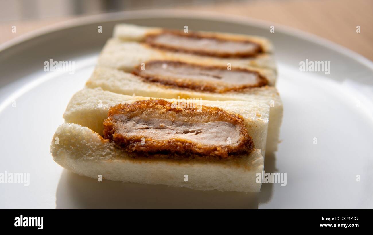 Pork cutlet tonkatsu sandwich or katsu sando is a popular quick convenient snack food in Japanese cuisine food in stores, subway shops, and malls. Stock Photo