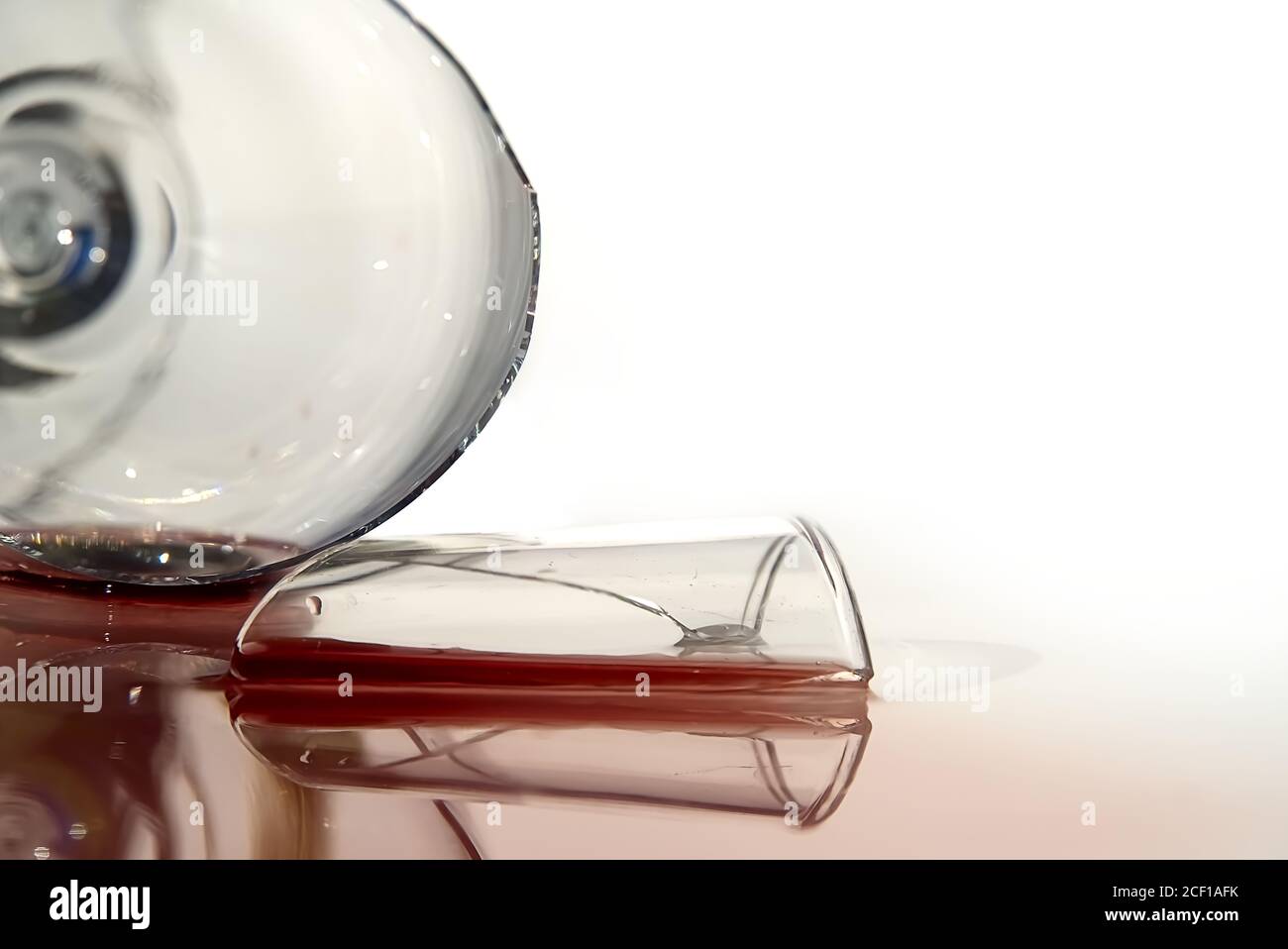 Broken wine glass with red wine. Glass of wine, broken on the mirror