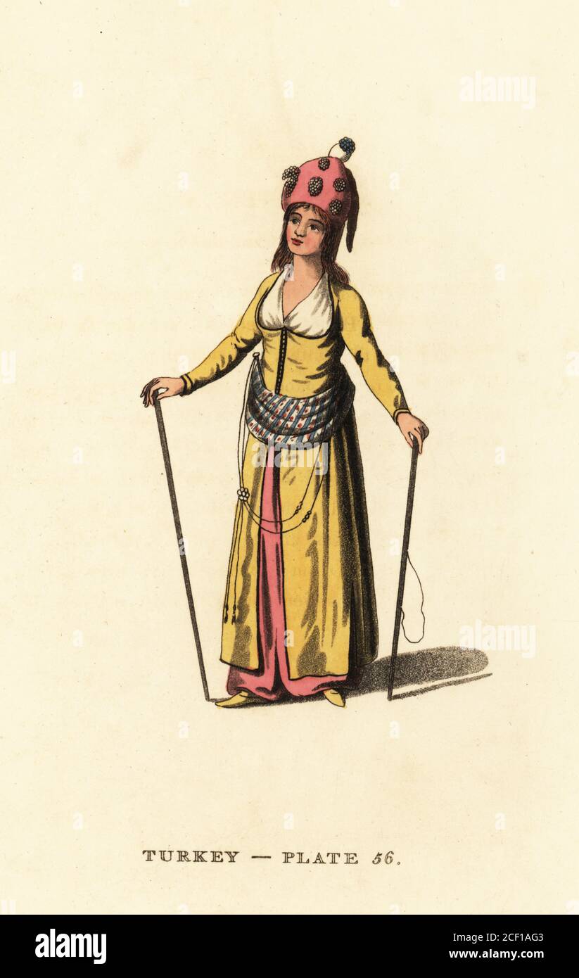 Attendant to the Harem of the Sultan. She wears a tall hat, yellow robes and slippers, girdle, and staffs. She keeps order in the Seraglio and punishes the Odalisks. Handcoloured copperplate engraving after Octavian Dalvimart from William Alexander’s translation of Picturesque Representations of the Dress and Manners of the Turks, Thomas M’Lean, London, 1814. Stock Photo