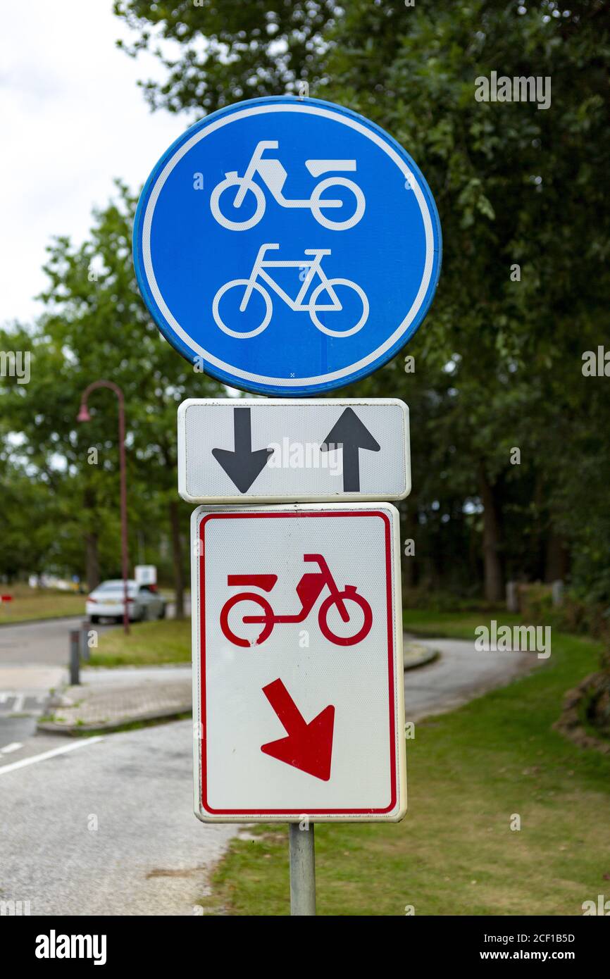 HULSEN, NETHERLANDS - Aug 02, 2020: Dutch street traffic sign with two-way bicycle and moped symbol meaning bikers have to use that lane and mopeds wi Stock Photo